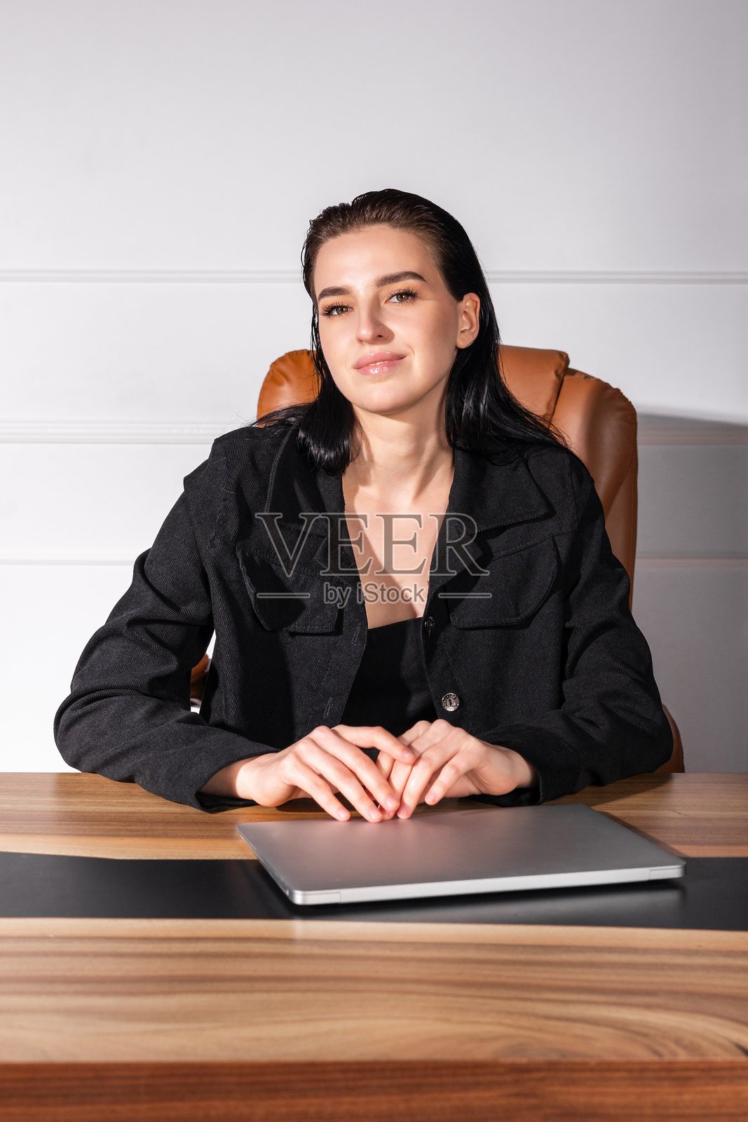 年轻女商人在现代办公室的会议中自信地坐在桌子旁。照片摄影图片