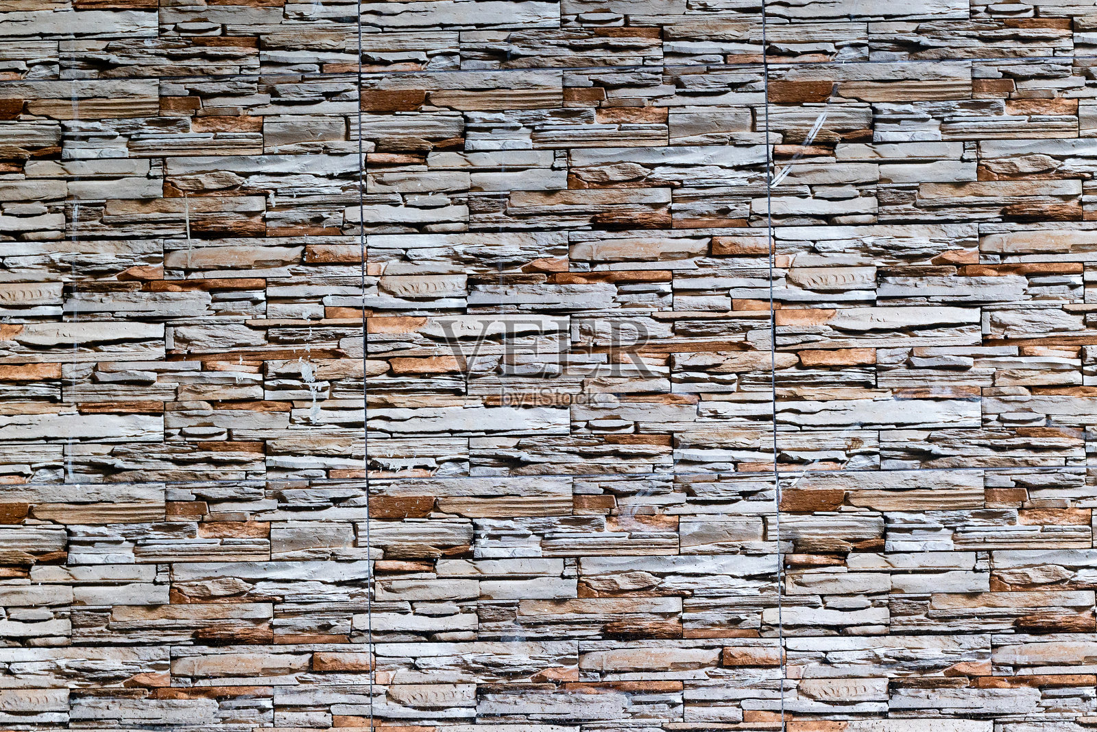 带有自然土色的纹理石砖墙，粗犷排列。照片摄影图片