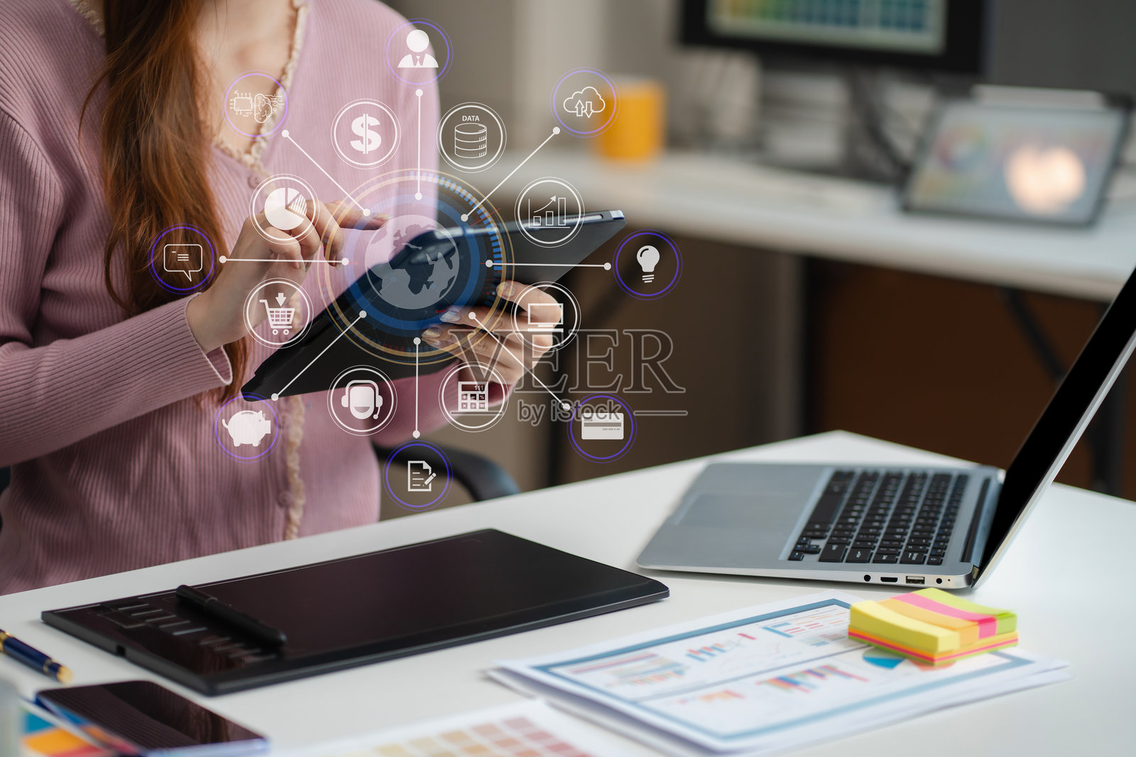 女性程序员或开发者在工作场所使用平板电脑和电脑显示器进行问题解决。照片摄影图片