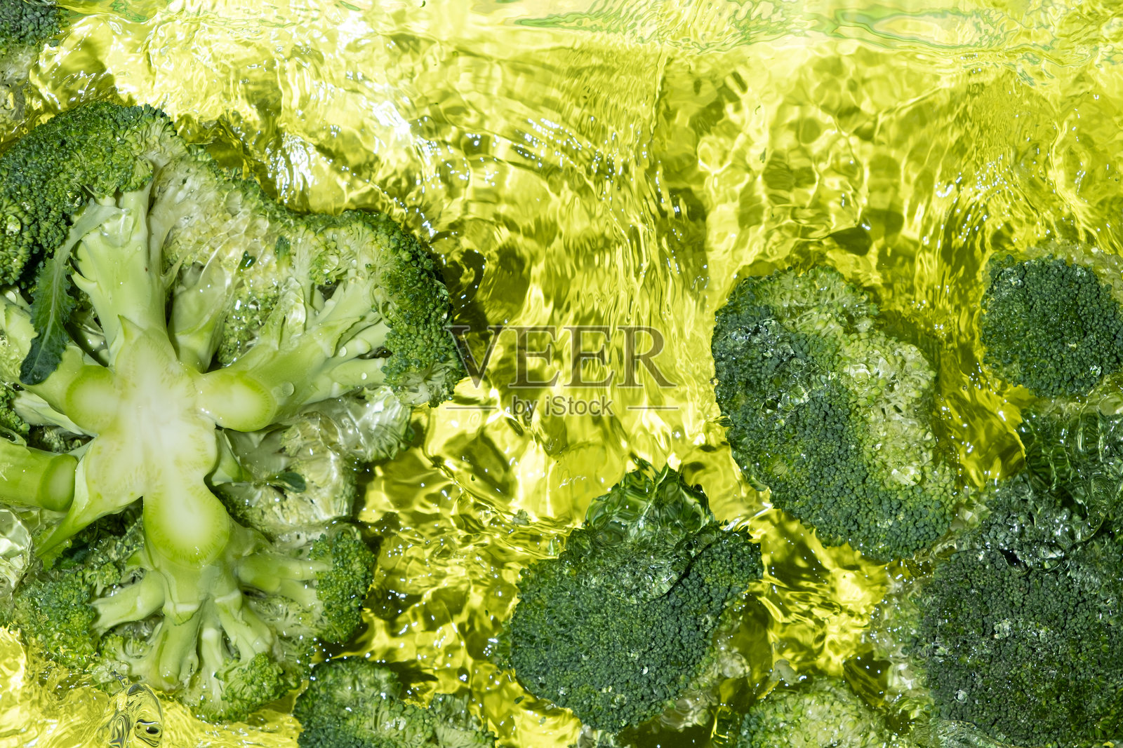 新鲜西兰花漂浮在水中，俯视图。照片摄影图片