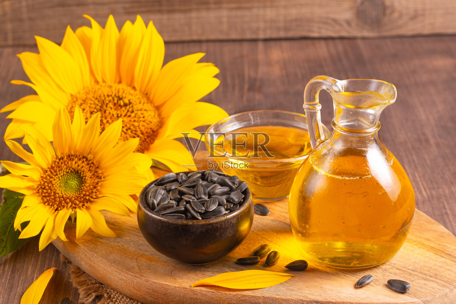 向日葵油和向日葵种子放在传统的乡村木质背景上。 有机和生态食品概念。 健康食品和脂肪。照片摄影图片