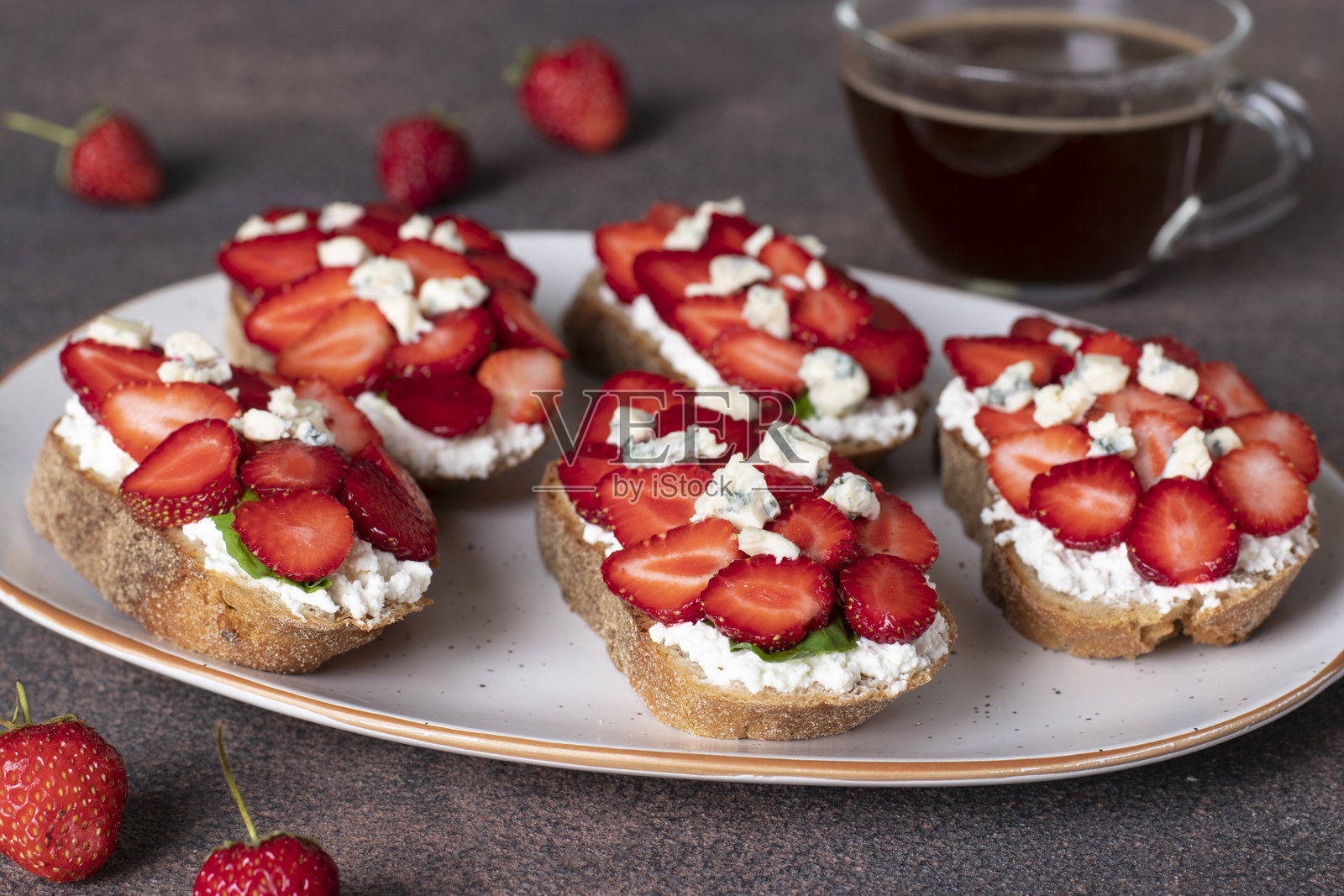 早餐草莓、芝麻菜和蓝纹奶酪的意式烤面包照片摄影图片