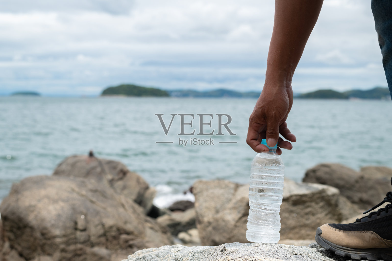 一个人手持塑料水瓶照片摄影图片