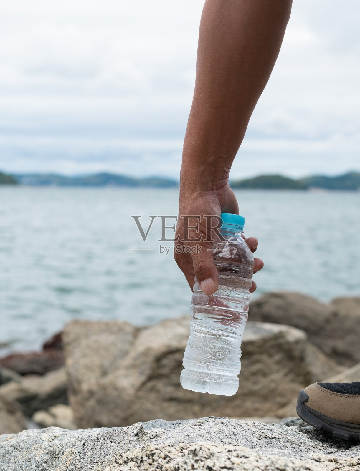 一个人手持塑料水瓶照片摄影图片