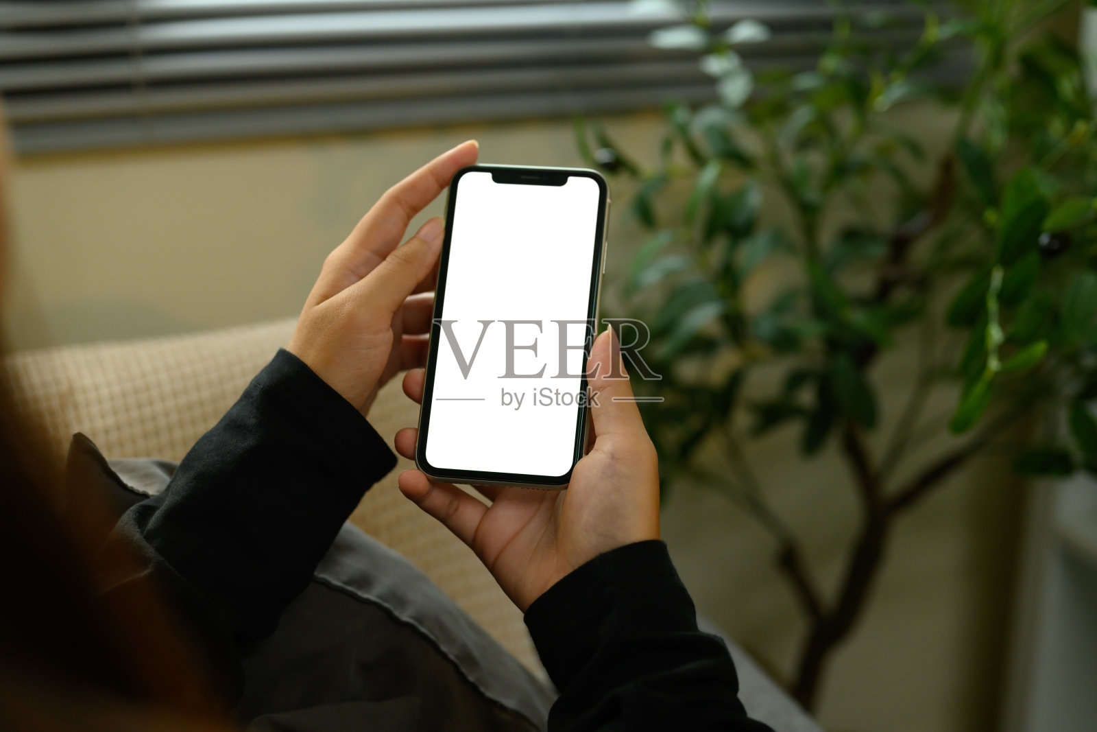 特写镜头下的女性手持一部空白白色屏幕的智能手机照片摄影图片