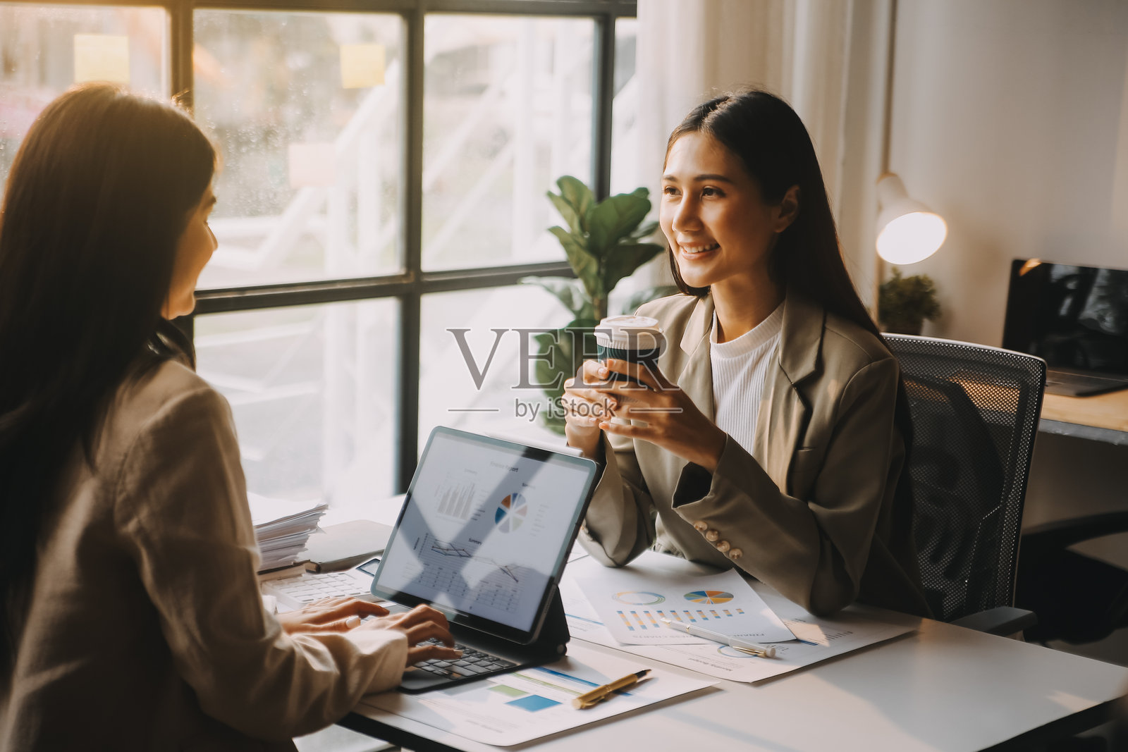 两位年轻的亚洲女商人在办公室讨论、咨询、分析新创业项目的想法、计划、市场营销和投资。照片摄影图片