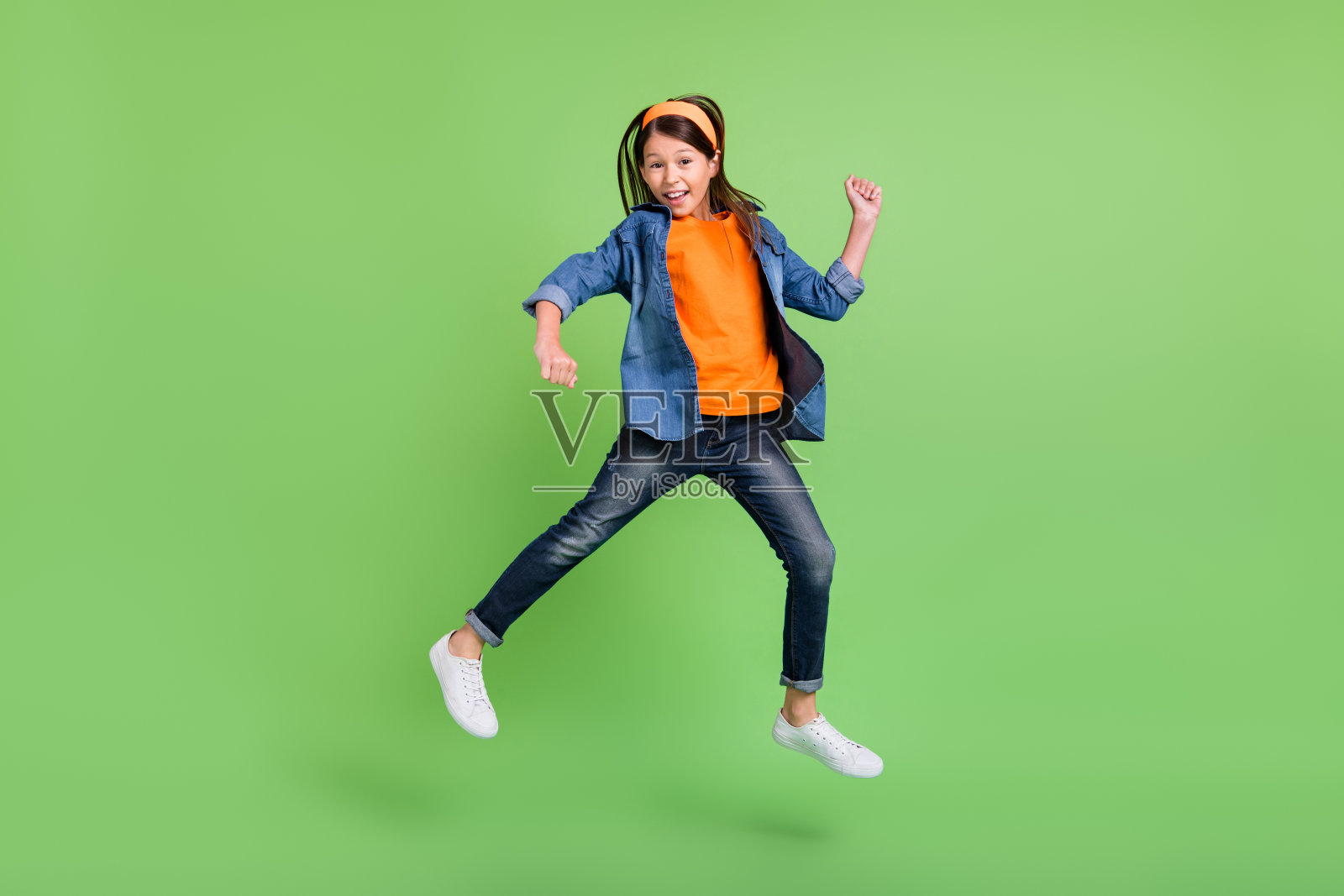 全身照，酷炫搞笑的小女孩穿着舞蹈服、牛仔裤和鞋子，背景为绿色。照片摄影图片