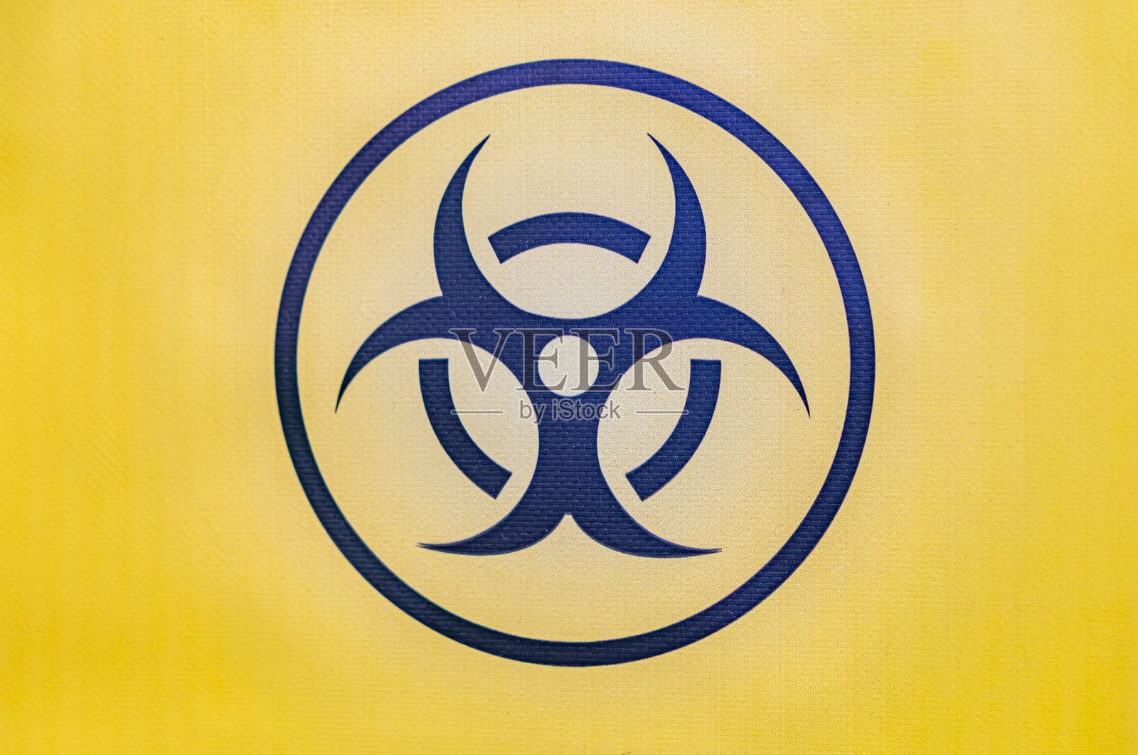 黄色渐变背景上的危险符号，深蓝色、浅蓝色和白色区域，中央原子图示带有蓝色能量轨道照片摄影图片