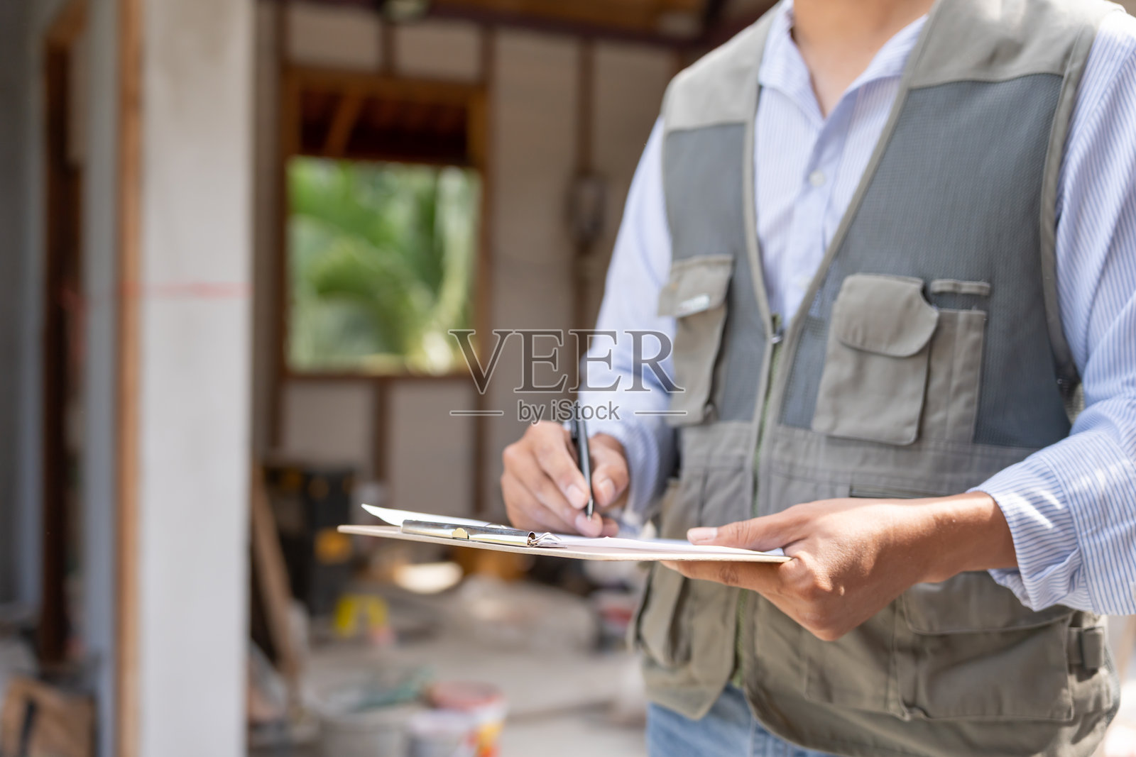 检查员或工程师正在使用检查表对新房的施工和质量进行检查。工程师、建筑师或承包商在将房屋交给业主之前进行建造工作。照片摄影图片