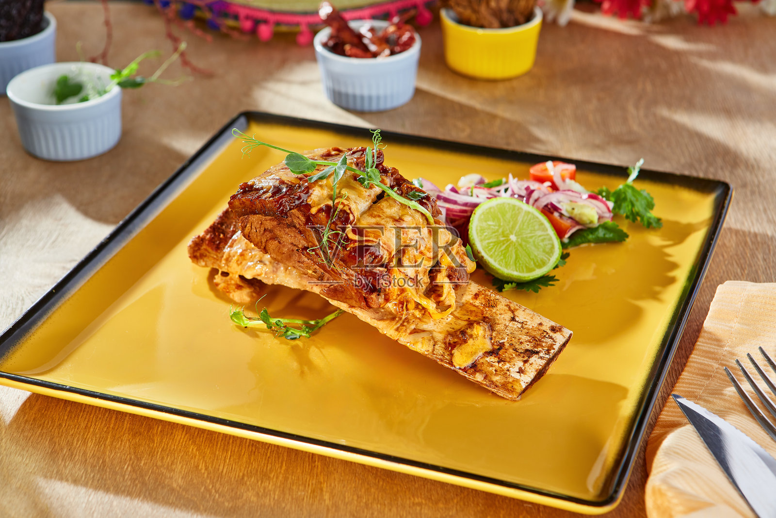 墨西哥风味的炖排骨配奶酪，明亮的环境光线，倾斜的桌面构图照片摄影图片