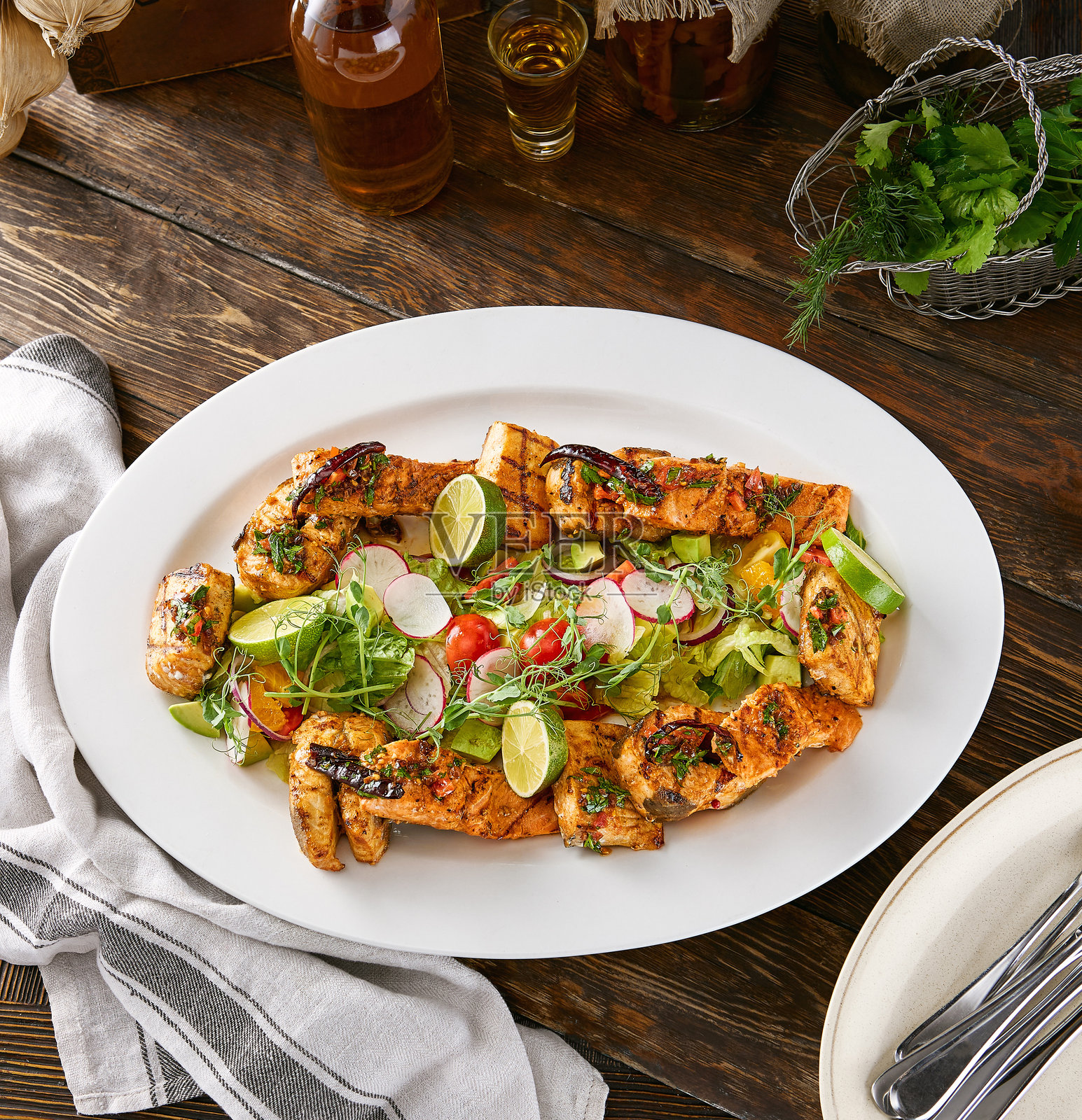 明亮乡村风格的木桌上，摆放着香草烤鱼拼盘。照片摄影图片