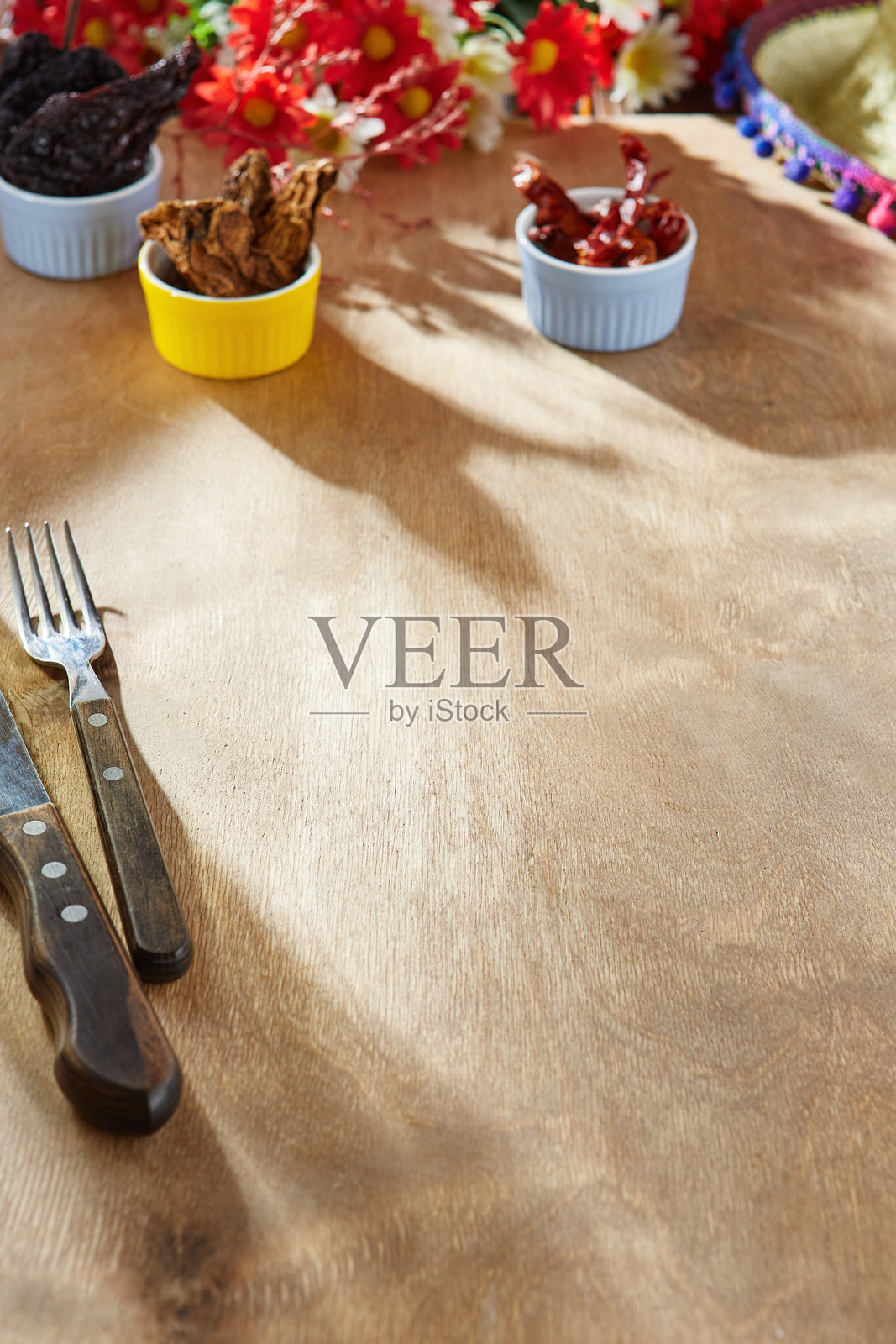 木质餐桌上摆放着干辣椒和餐具，阳光明媚的氛围，俯视构图适合墨西哥菜单照片摄影图片