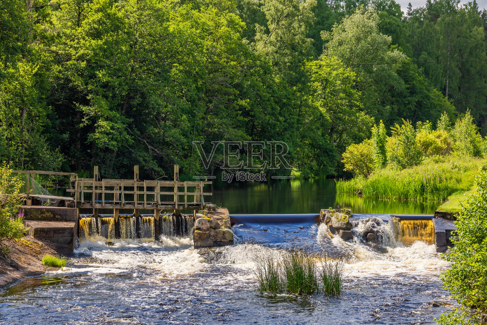 阳光明媚的夏日，瀑布旁的闸门照片摄影图片