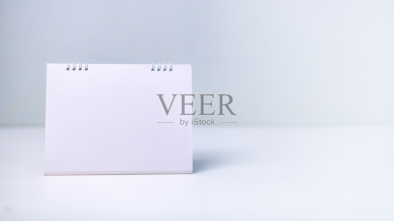 一张空白的白色日历放在干净的表面上，象征着新的开始、未来规划、日程安排和重要日期。时间管理、生产力和目标设定的概念适用于任何项目或年度。照片摄影图片