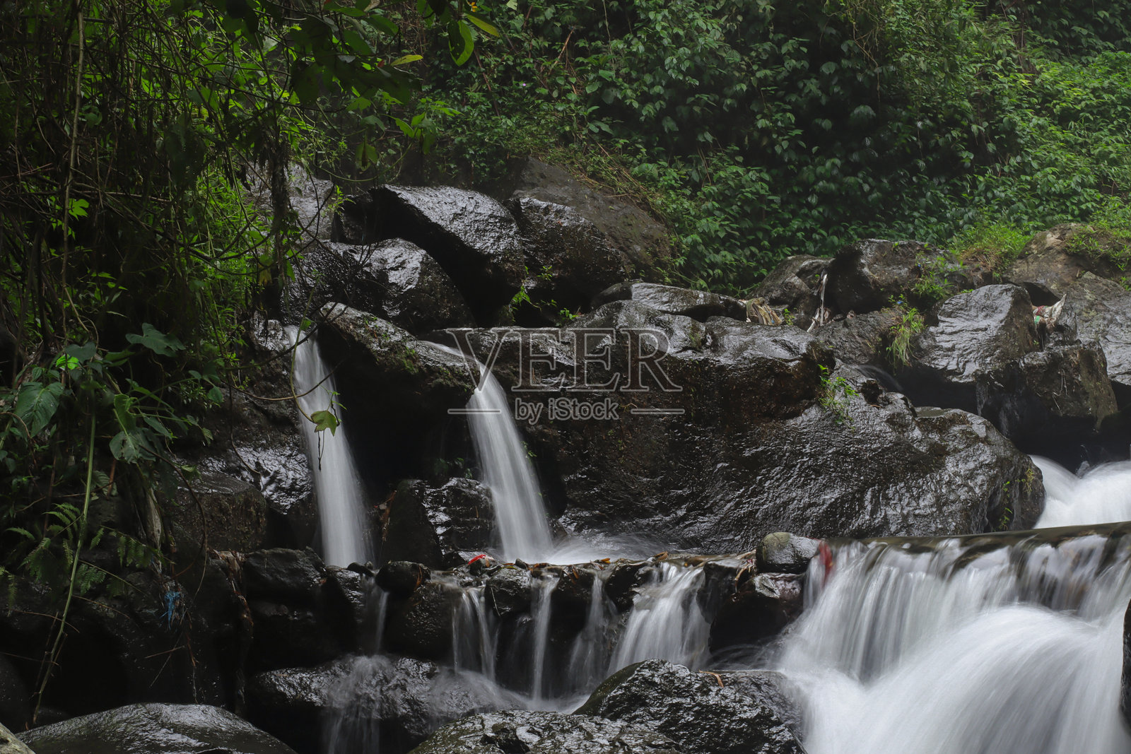 湿润火山岩上流动瀑布的特写照片摄影图片