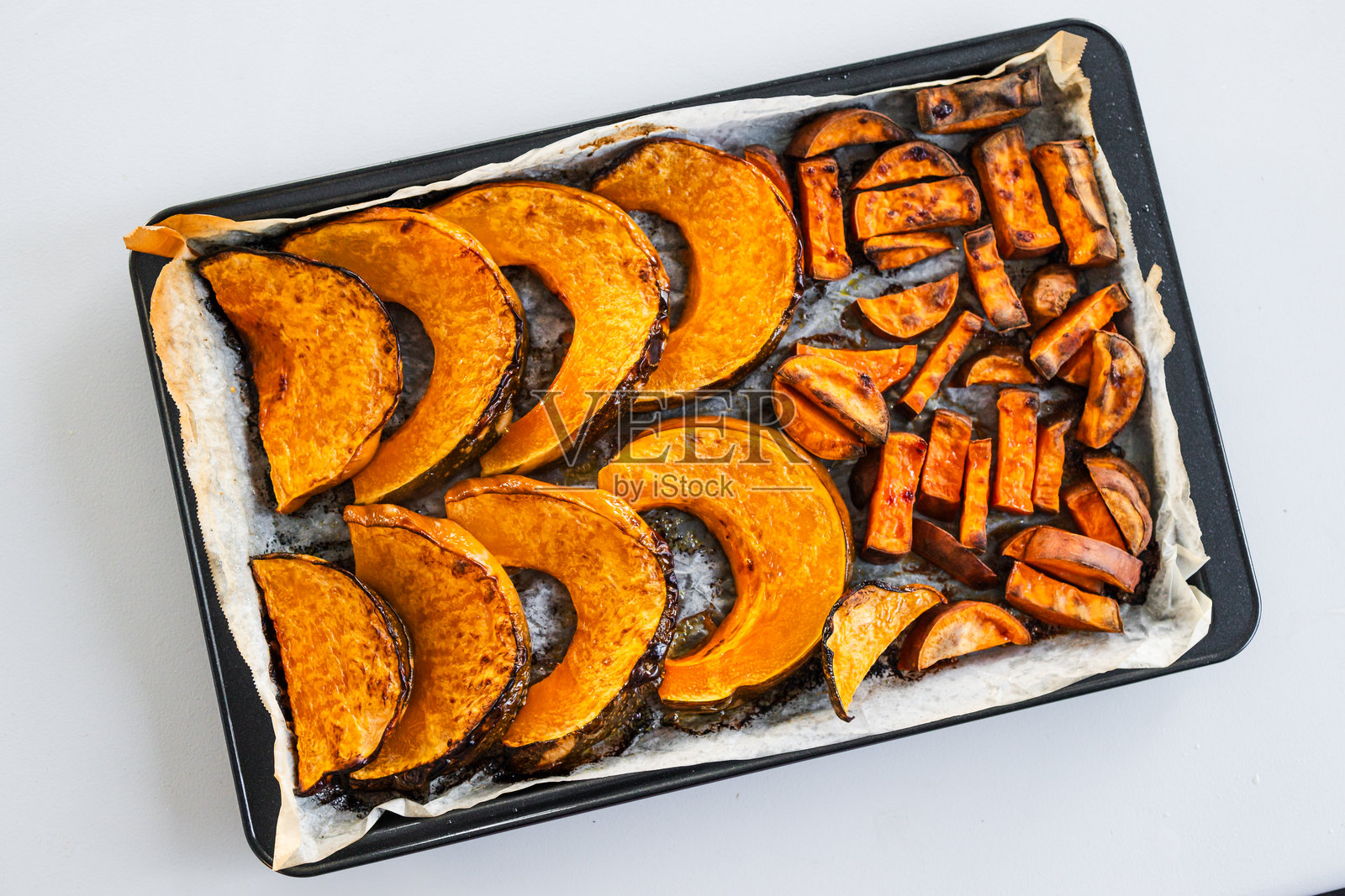 烤制的肯特南瓜片和红薯脆片放在烤盘上照片摄影图片