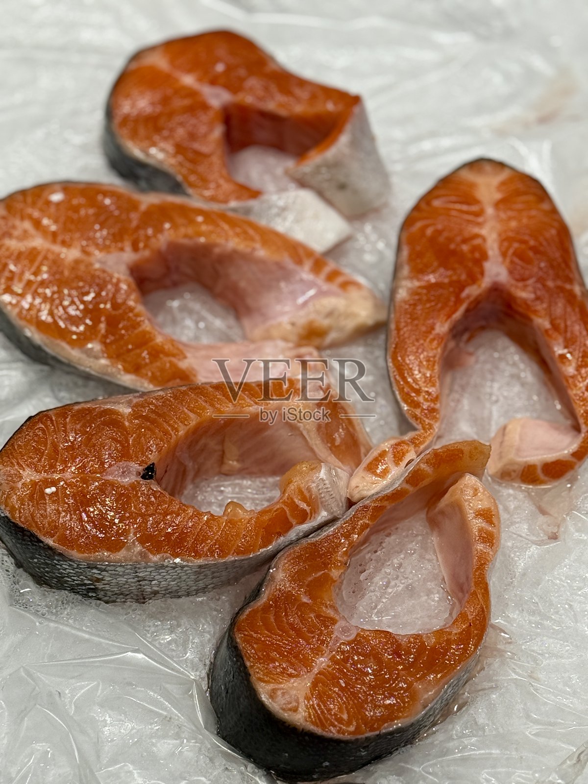 超市出售的冷冻生材料制成的冷冻大西洋鲑鱼牛排，特写镜头。照片摄影图片