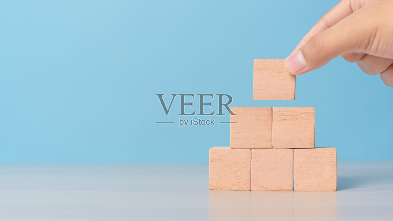 手工将空块放置成一排。规划、过程或顺序设置的概念。照片摄影图片