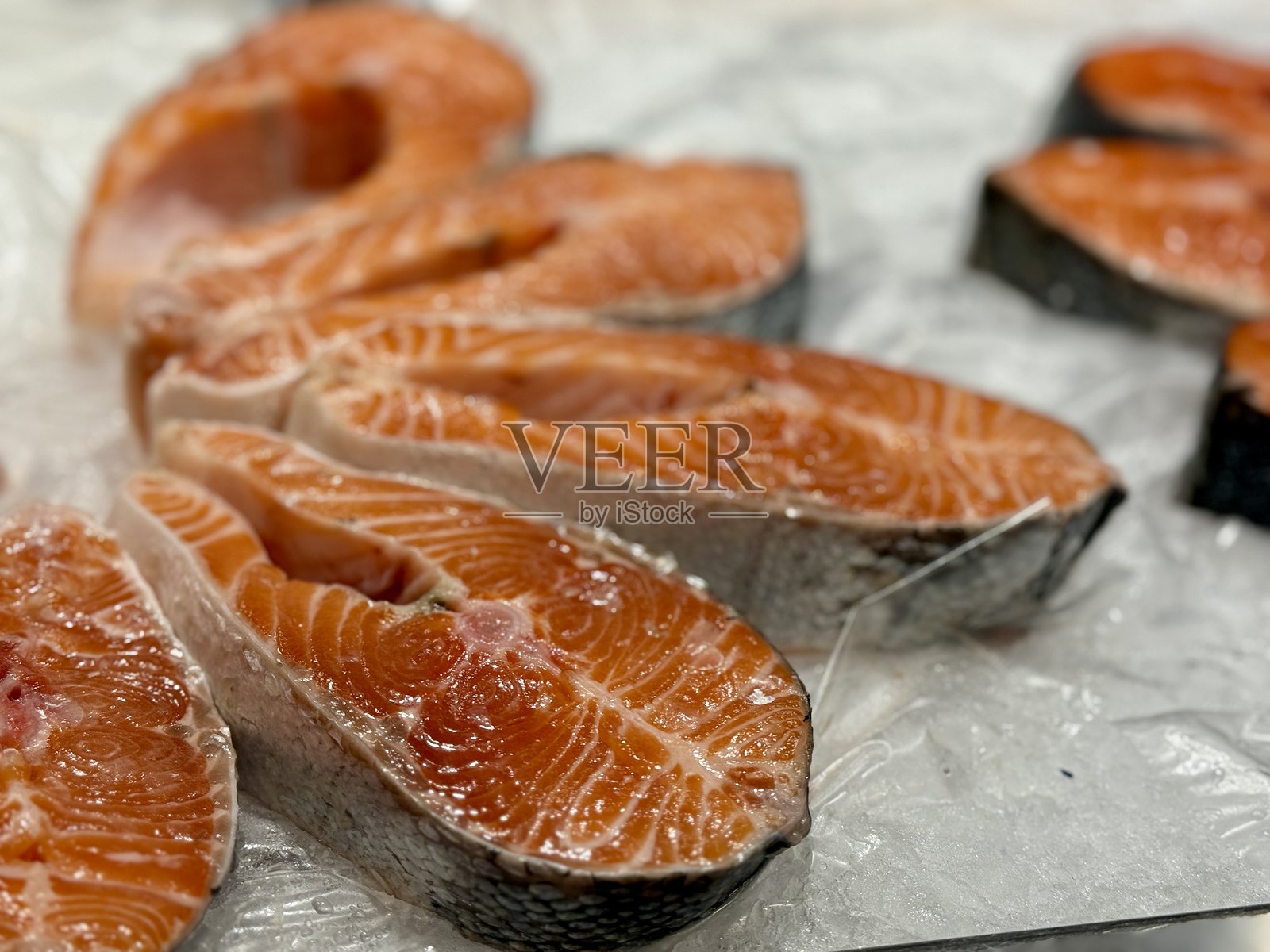 超市出售的冷冻原料制成的冷藏大西洋鲑鱼牛排，特写镜头。照片摄影图片