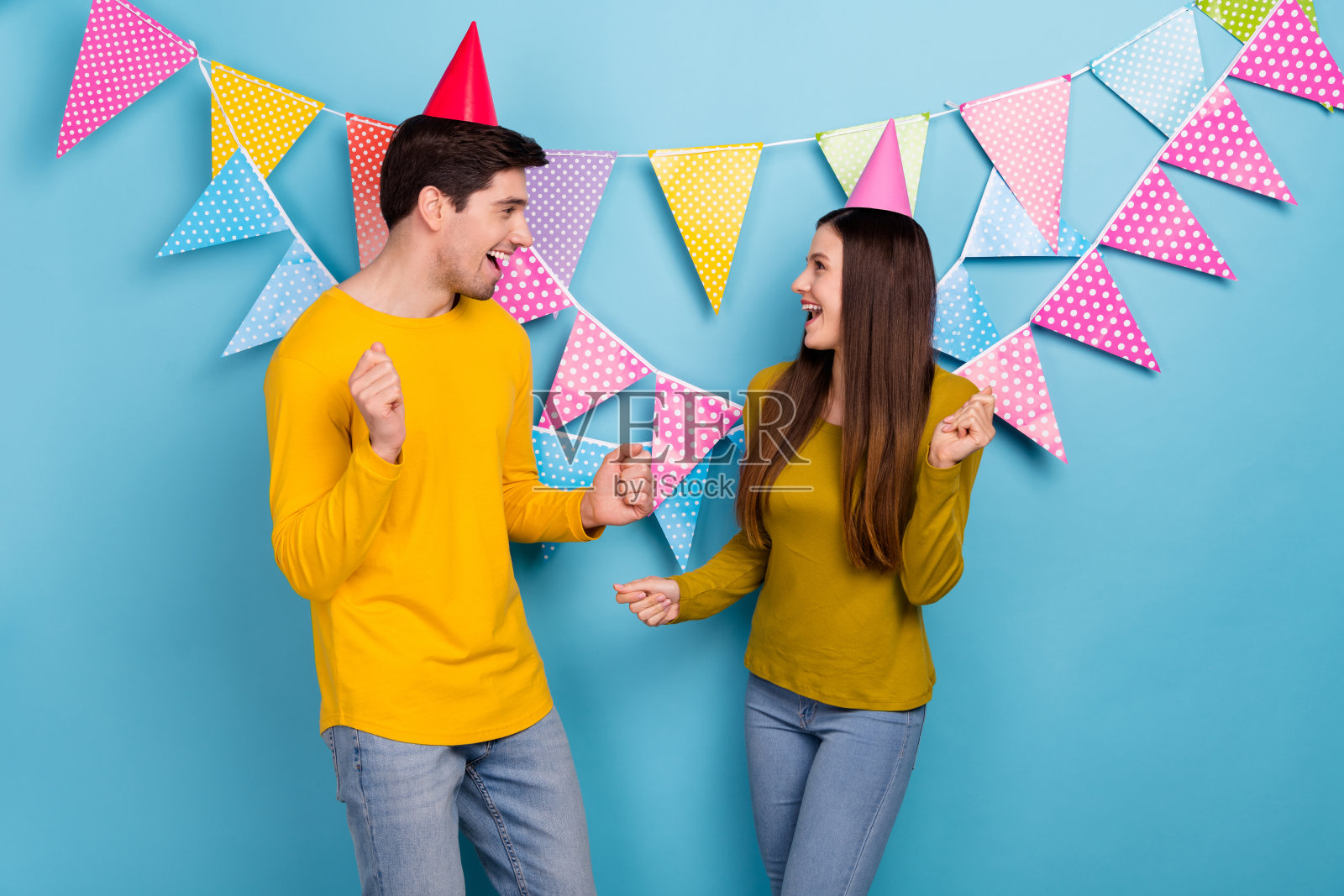 兴奋的夫妻在2月14日的婚礼庆典上热情舞蹈，背景为蓝色。照片摄影图片