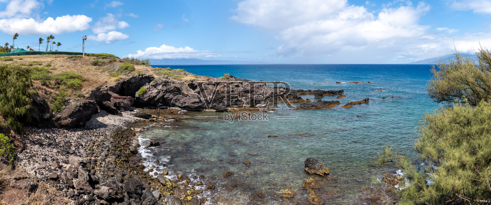 岩石海岸的全景，清澈的碧蓝海水和蓝天。照片摄影图片