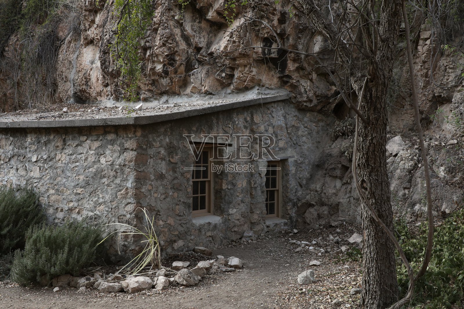 靠在岩石墙上的传统石屋，博伊斯·汤普森植物园，亚利桑那州照片摄影图片