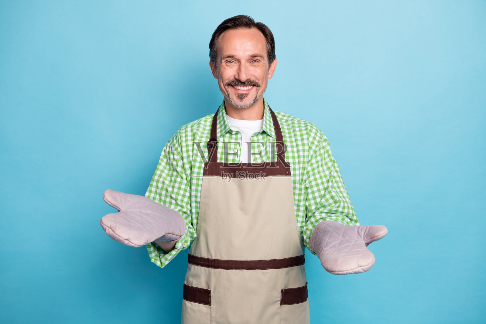 吸引人的快乐男士在明亮的蓝色背景下欢迎您参加家庭烹饪课程照片摄影图片