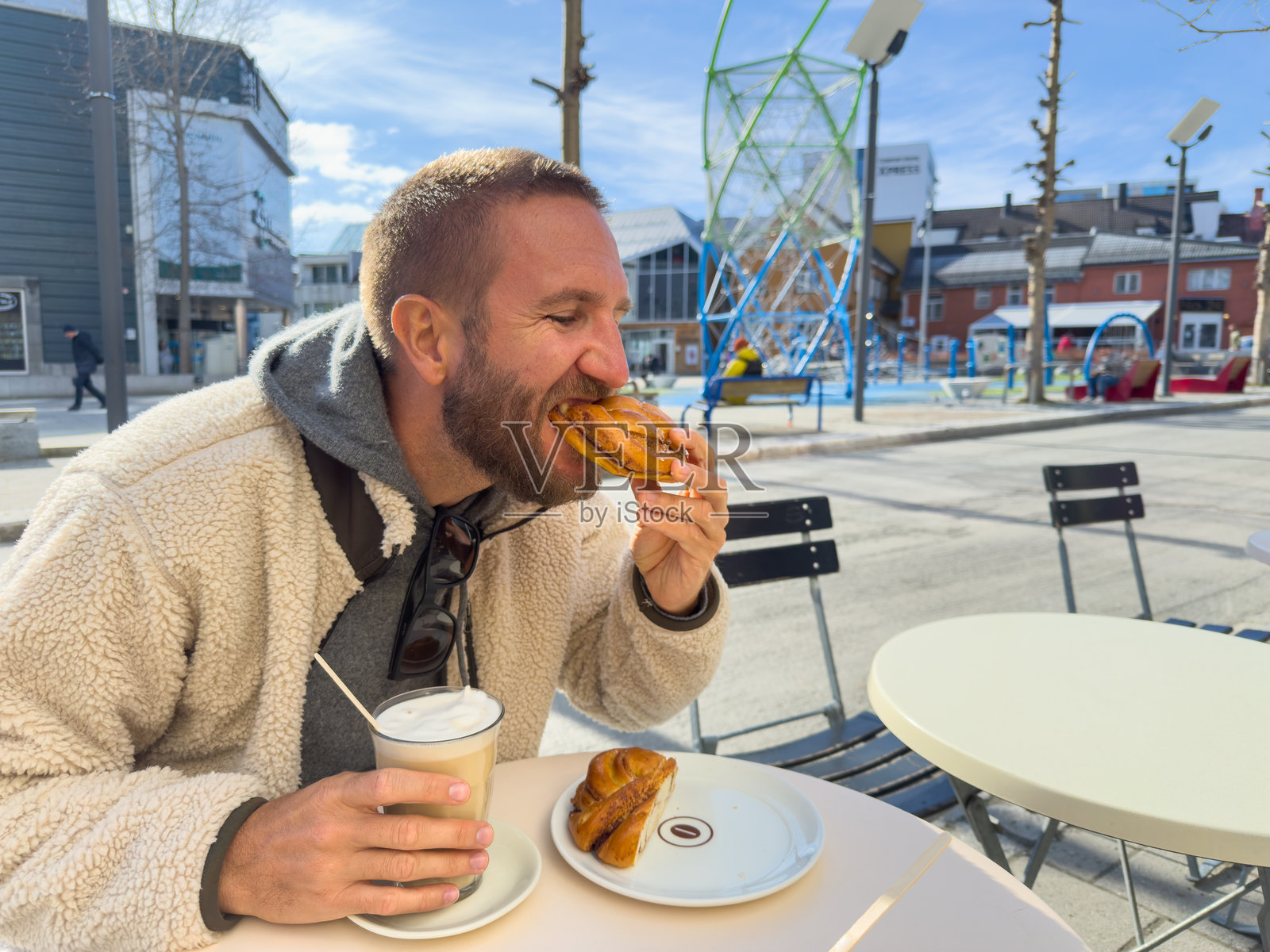 男人在户外咖啡馆享受咖啡和糕点照片摄影图片
