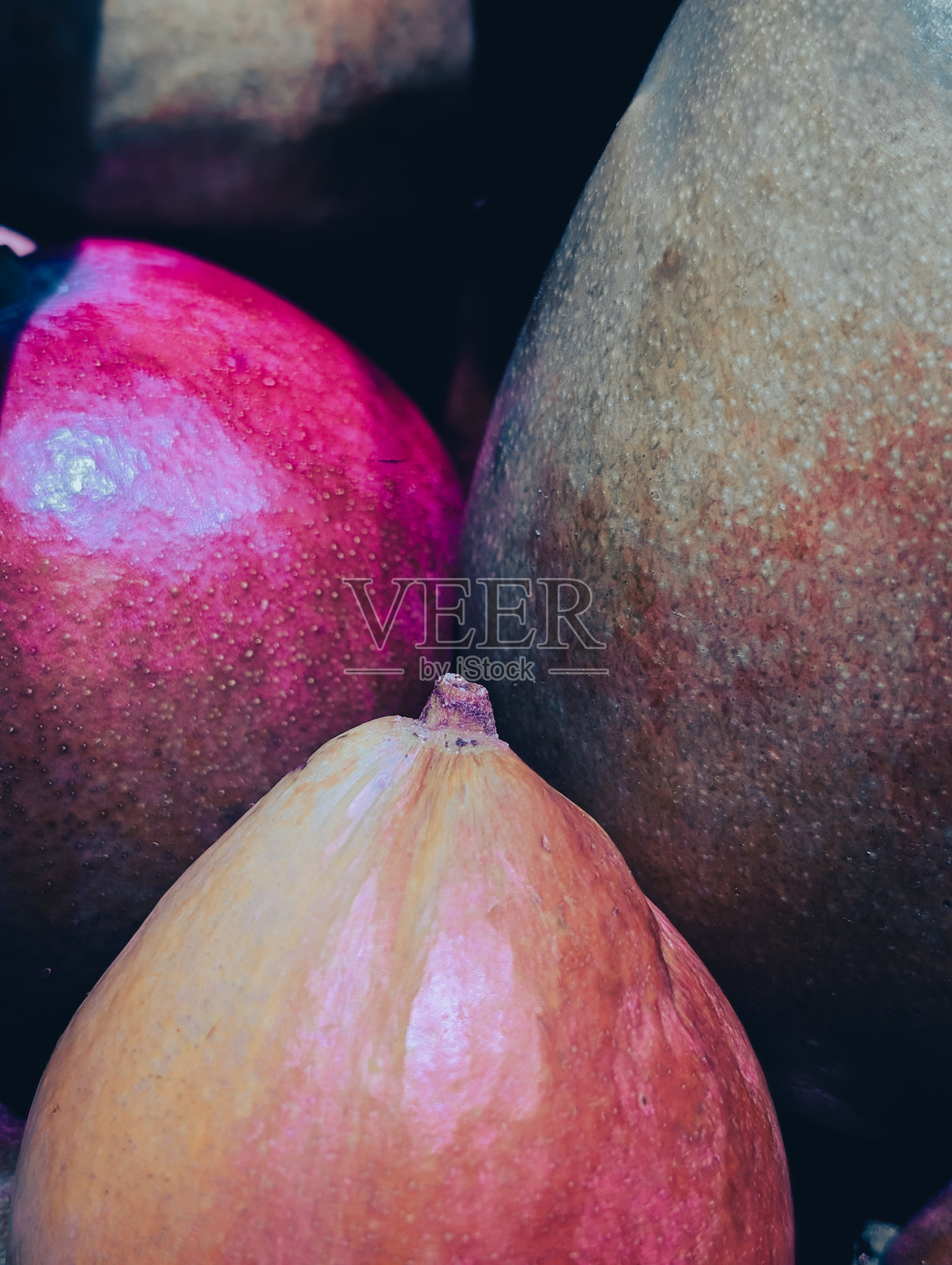 三只红绿相间的成熟芒果的垂直特写照片摄影图片