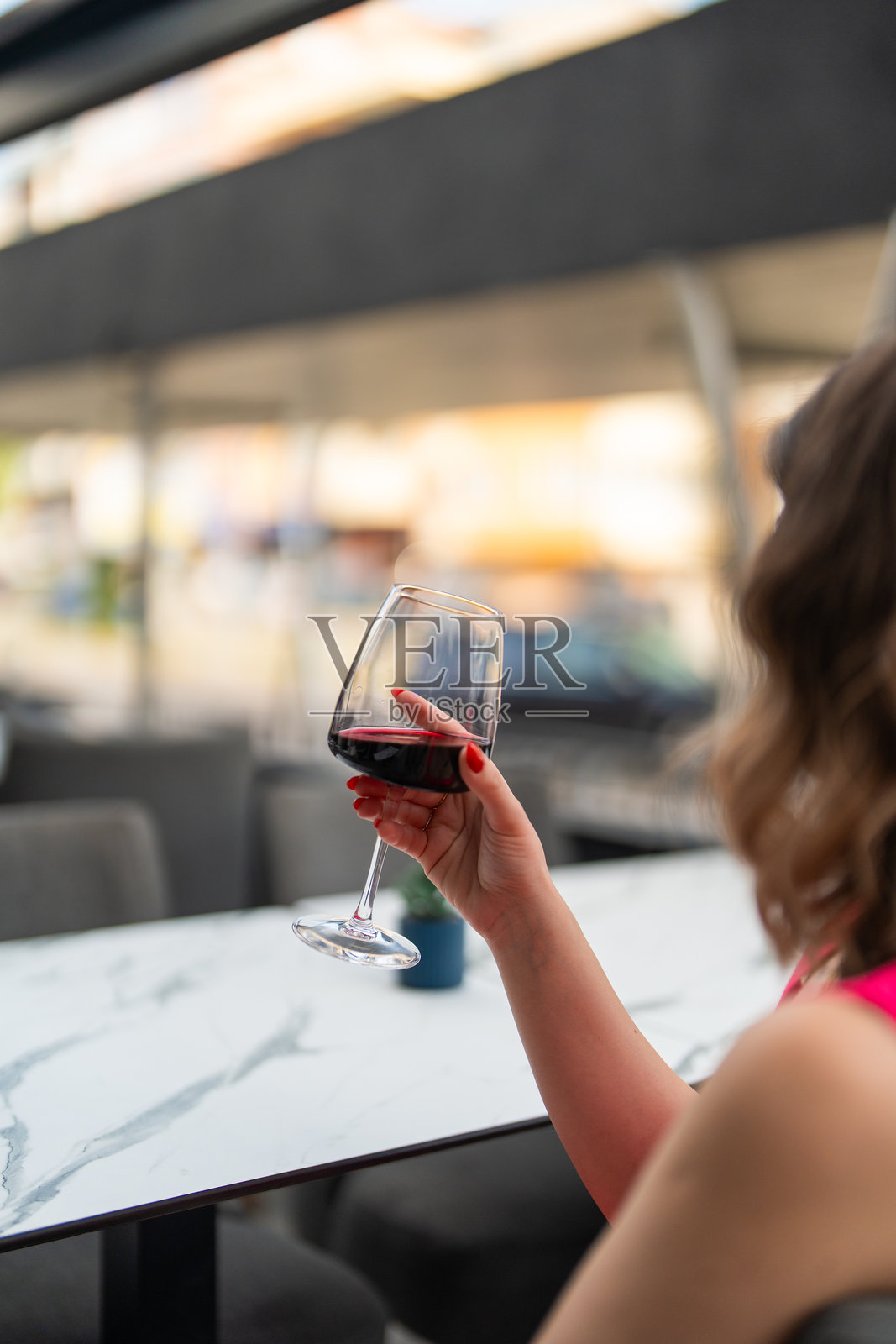 在户外咖啡馆里举着一杯红酒的女人照片摄影图片