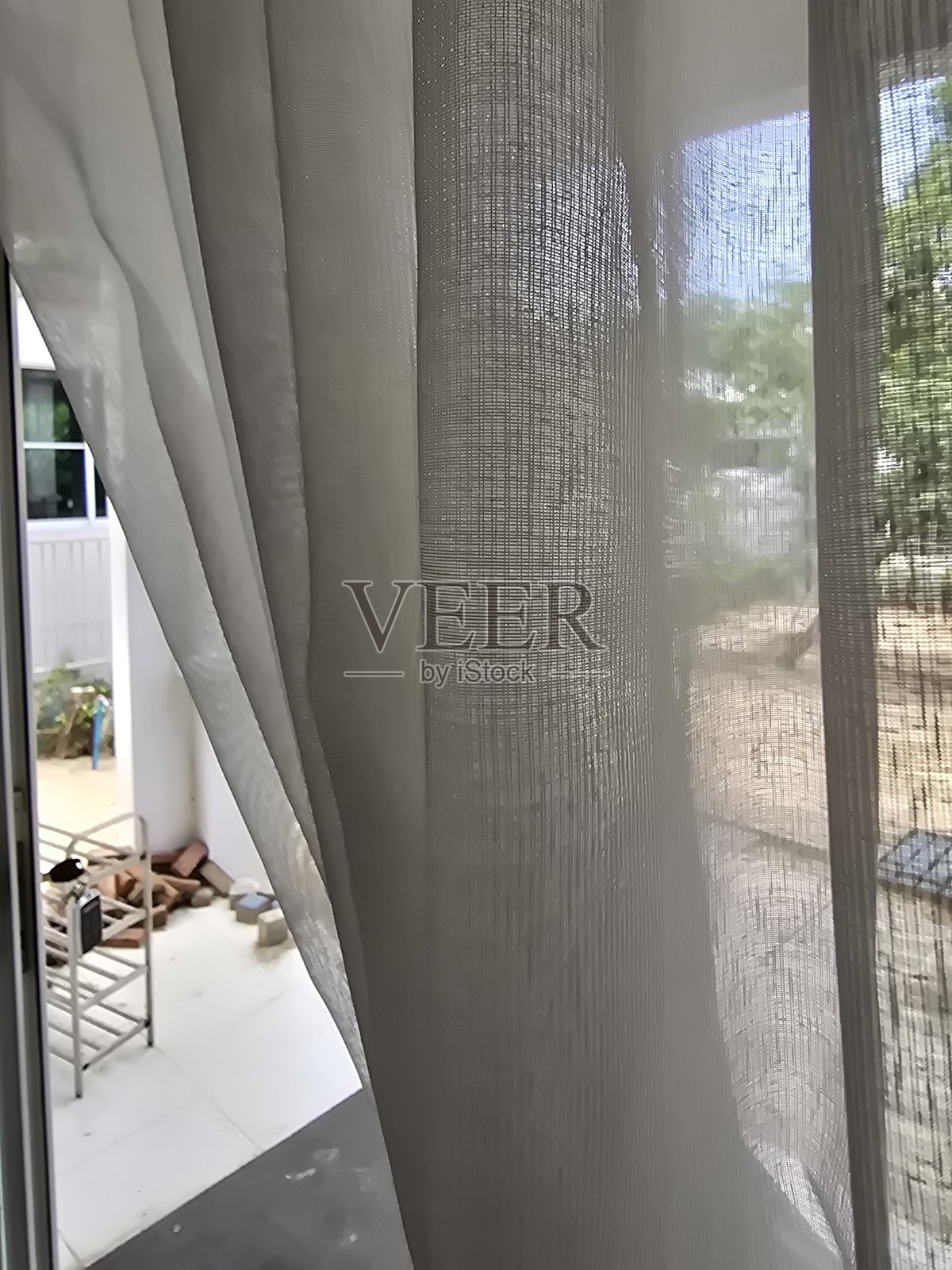 柔和的窗帘过滤着光线，窗外景色与细腻的纹理照片摄影图片