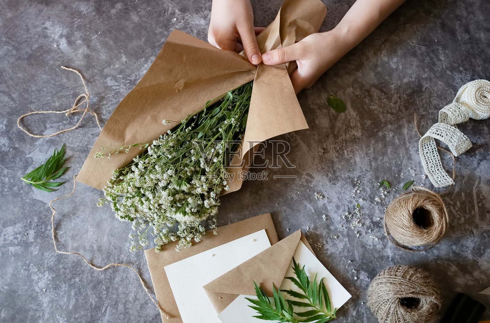 在温馨的手工制作空间里，用自然材料在有纹理的表面上制作乡村风格的花卉布置照片摄影图片