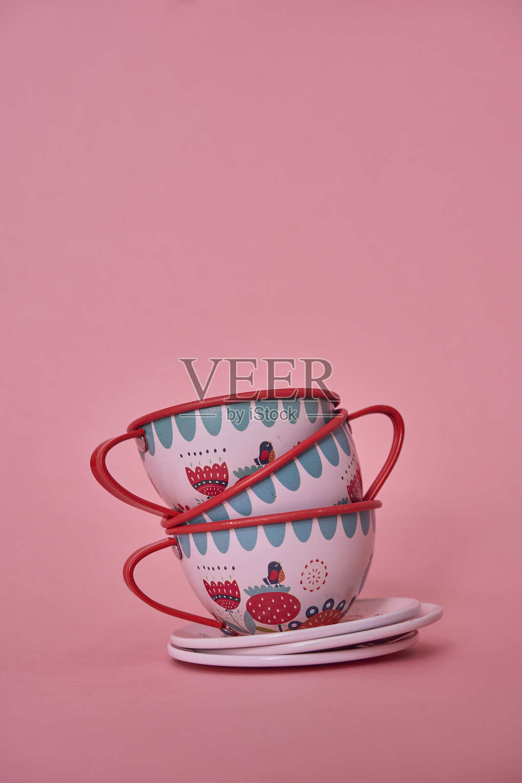 一套红白色的茶壶玩具，背景为粉色。照片摄影图片