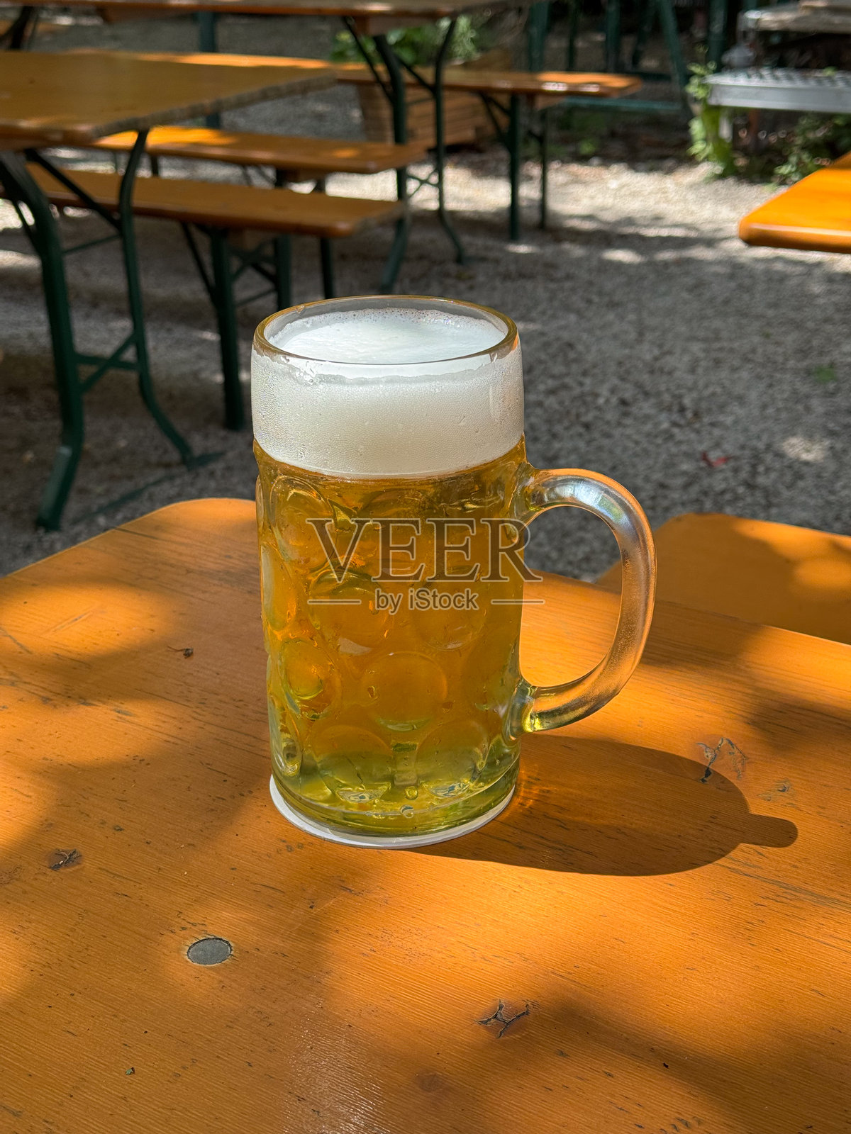 手握一升的慕尼黑啤酒节啤酒杯，在啤酒大厅的户外酒吧庆祝活动中照片摄影图片