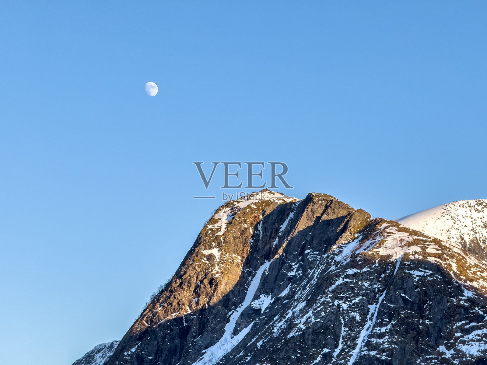 日出时分的雄伟山脉与天空中的月亮照片摄影图片