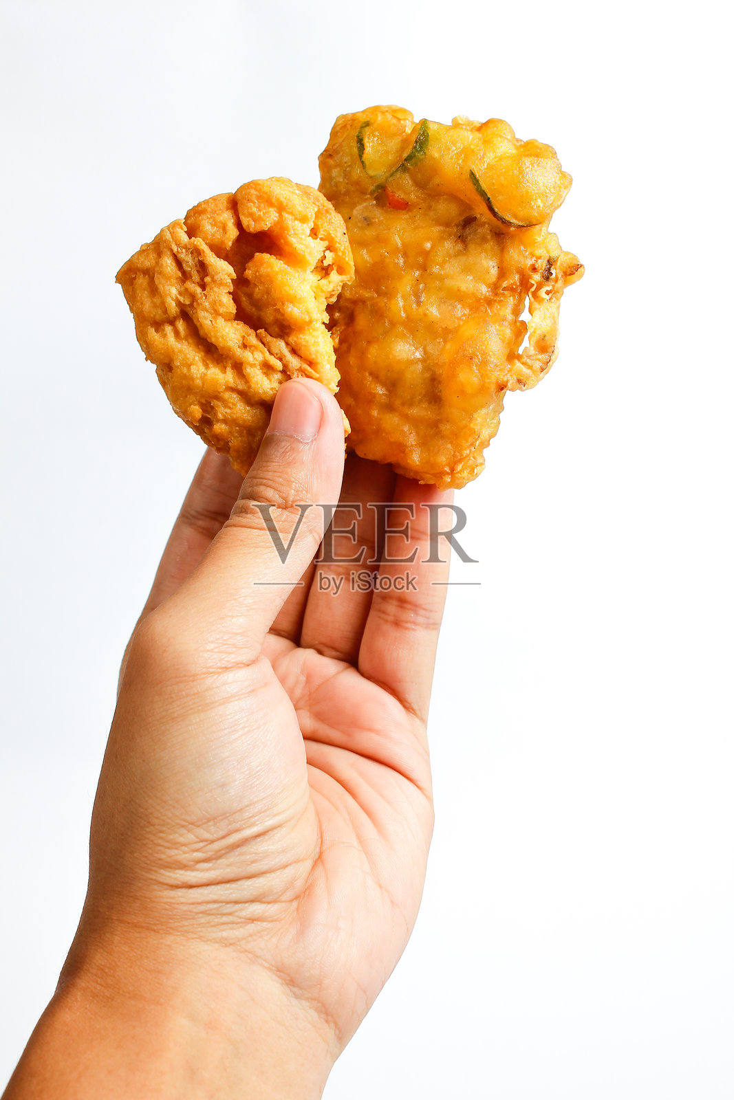 手握炸天贝和炸豆腐，背景为白色照片摄影图片