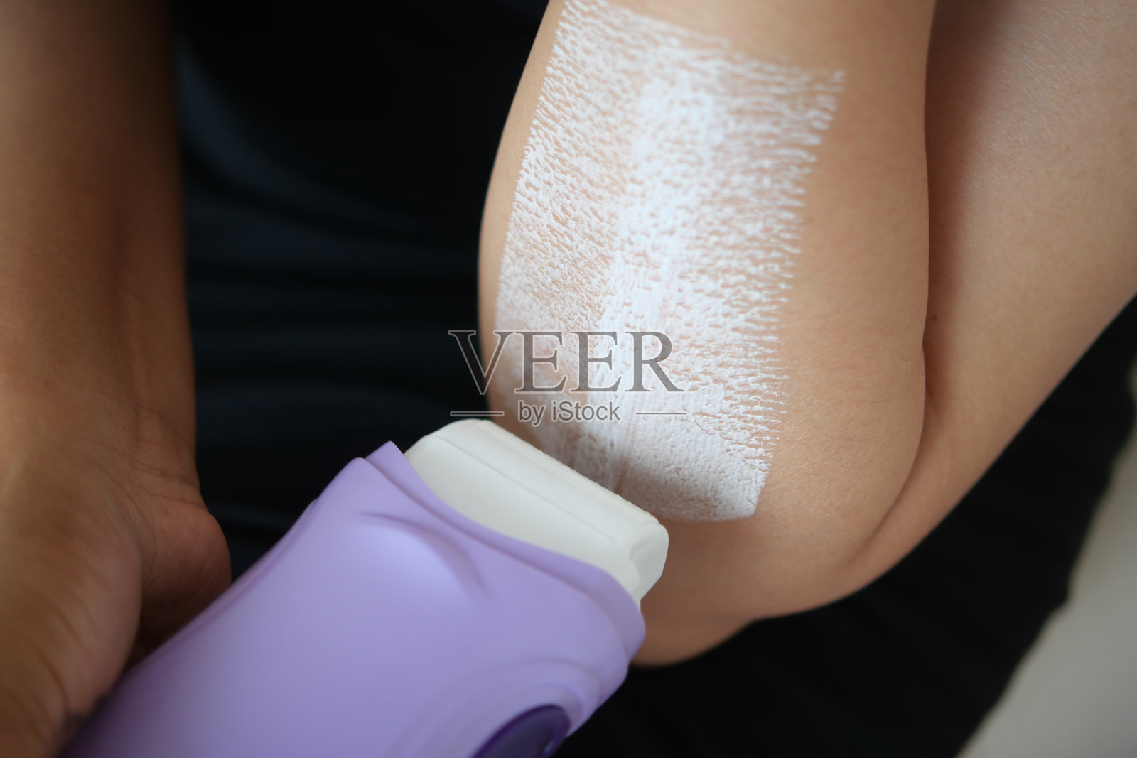 在明亮的房间里涂抹脱毛膏于肘部照片摄影图片