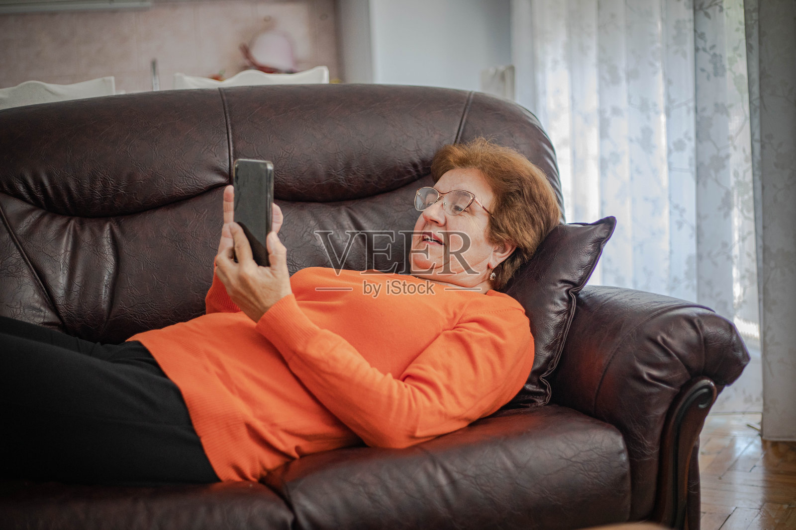 一位老年女性正在使用智能手机照片摄影图片
