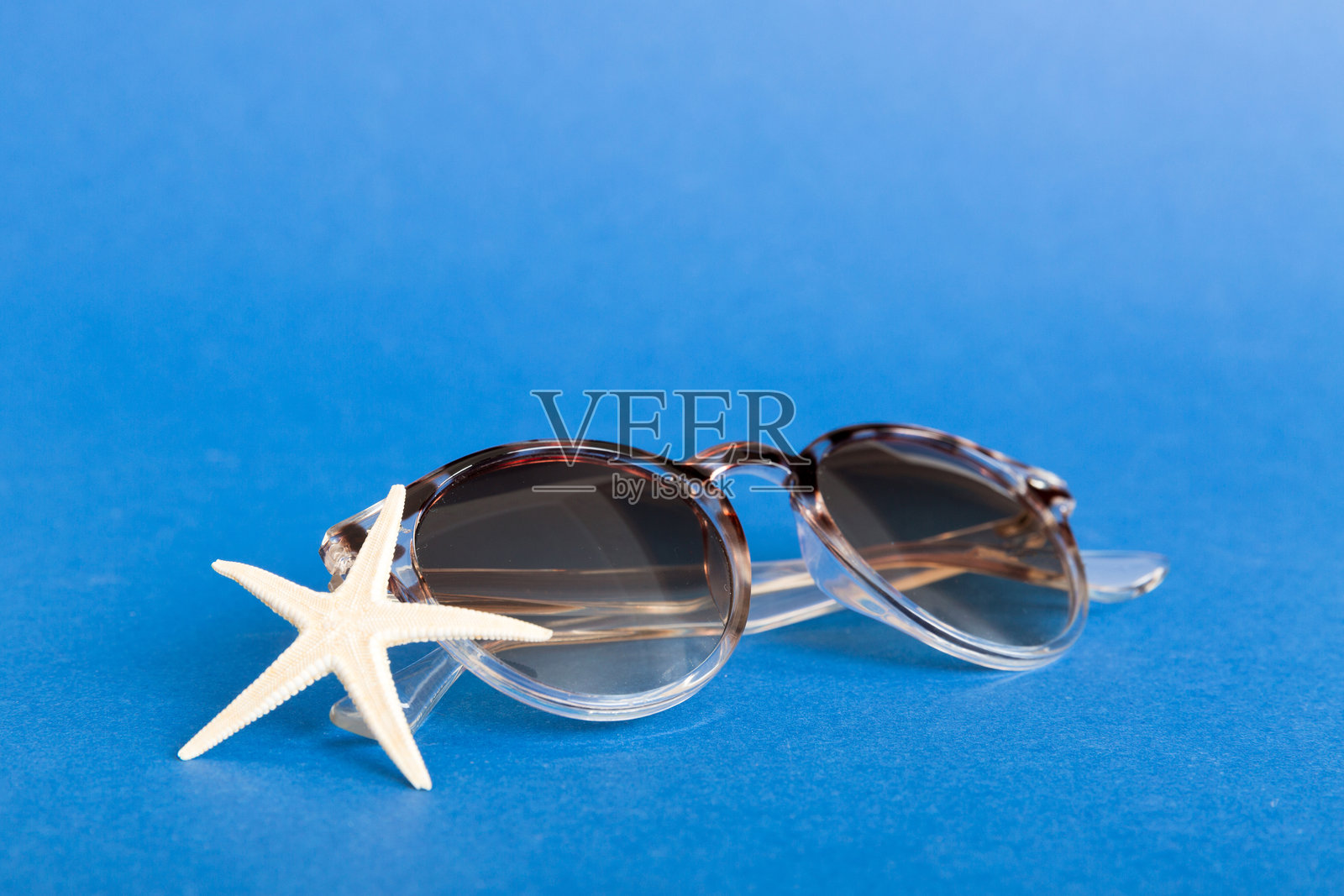 桌面背景上的太阳镜与海螺。夏季背景上的太阳镜。俯视平铺，留有文本空白。照片摄影图片