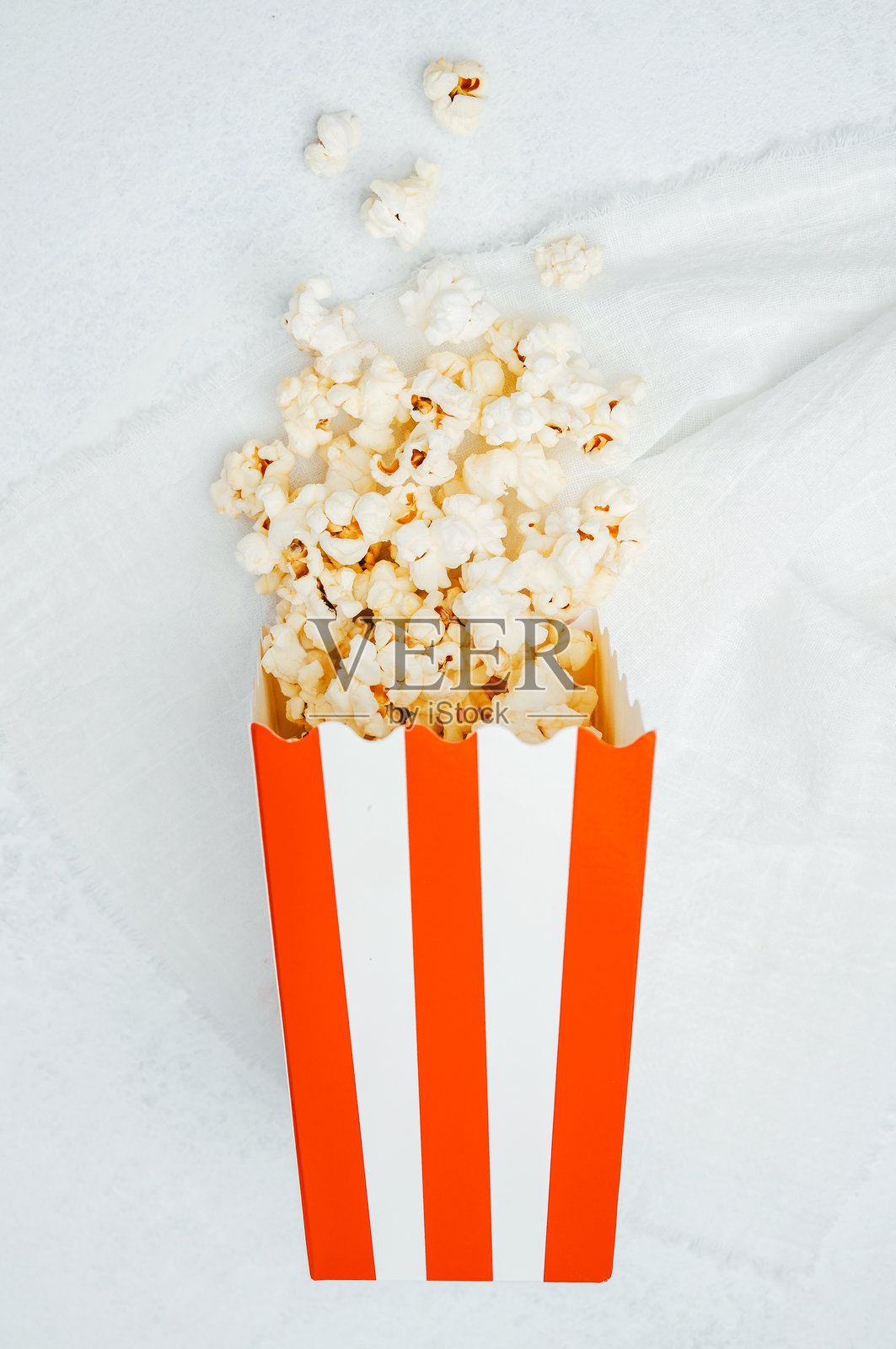 新鲜爆米花装在条纹盒子里，准备好享受电影之夜的小吃时间照片摄影图片