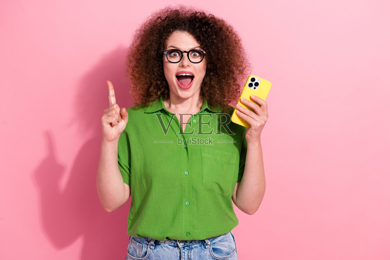 迷人且吸引人的女孩，棕色非洲卷发，穿着时尚的服装，脑海中有想法，空白空间，背景为粉色。照片摄影图片