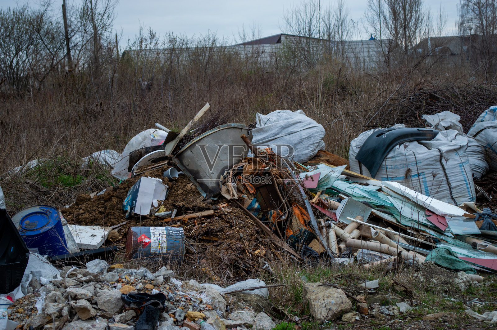 垃圾和杂物散落在一块被忽视的土地上，突显了农村地区废物管理的环境问题。照片摄影图片