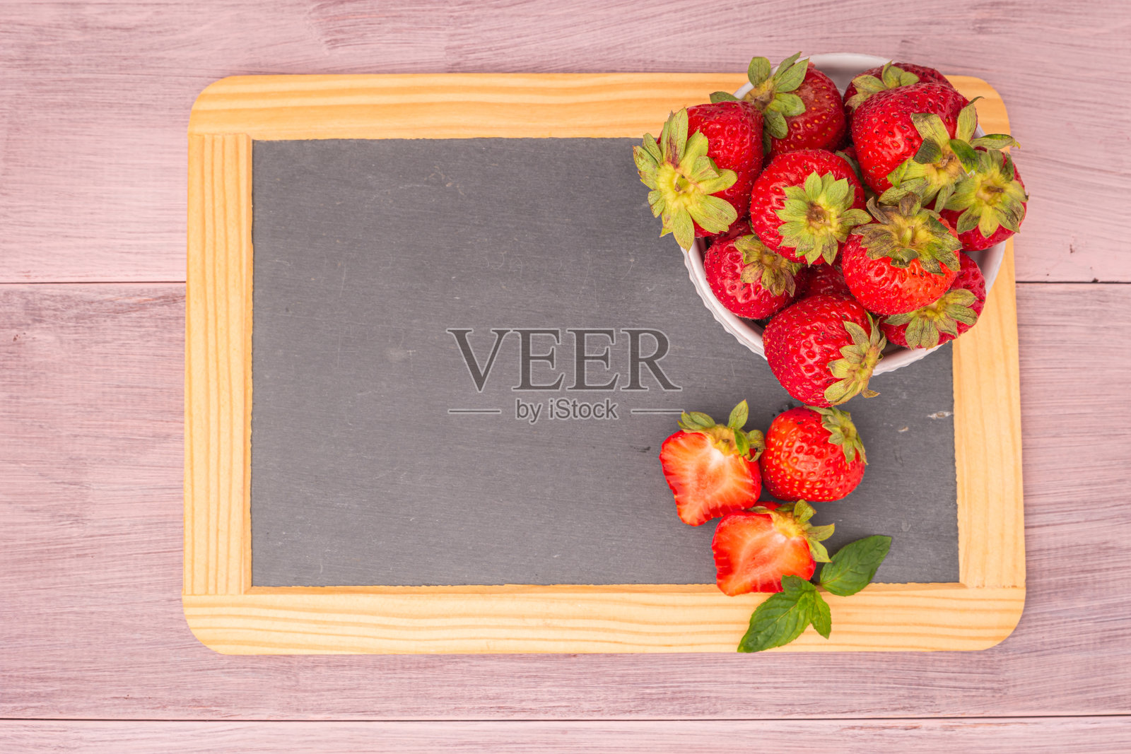 新鲜草莓放在石板上的碗里。俯视图，留有空白空间。照片摄影图片