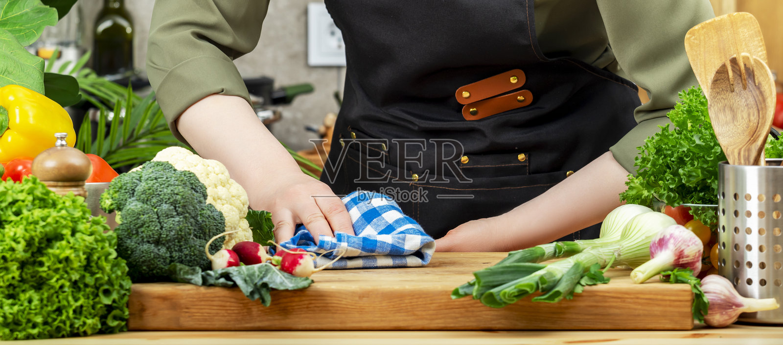 厨师用厨房毛巾擦拭切菜板，木桌，厨房用具，蔬菜，香草和烹饪食材。健康食品，饮食，烹饪，食谱，博客照片摄影图片