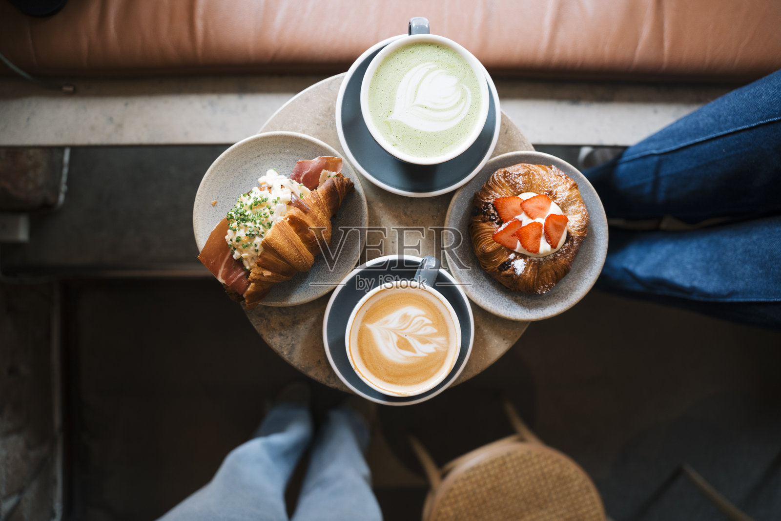 咖啡馆桌上摆放着手工食品、咖啡和抹茶照片摄影图片