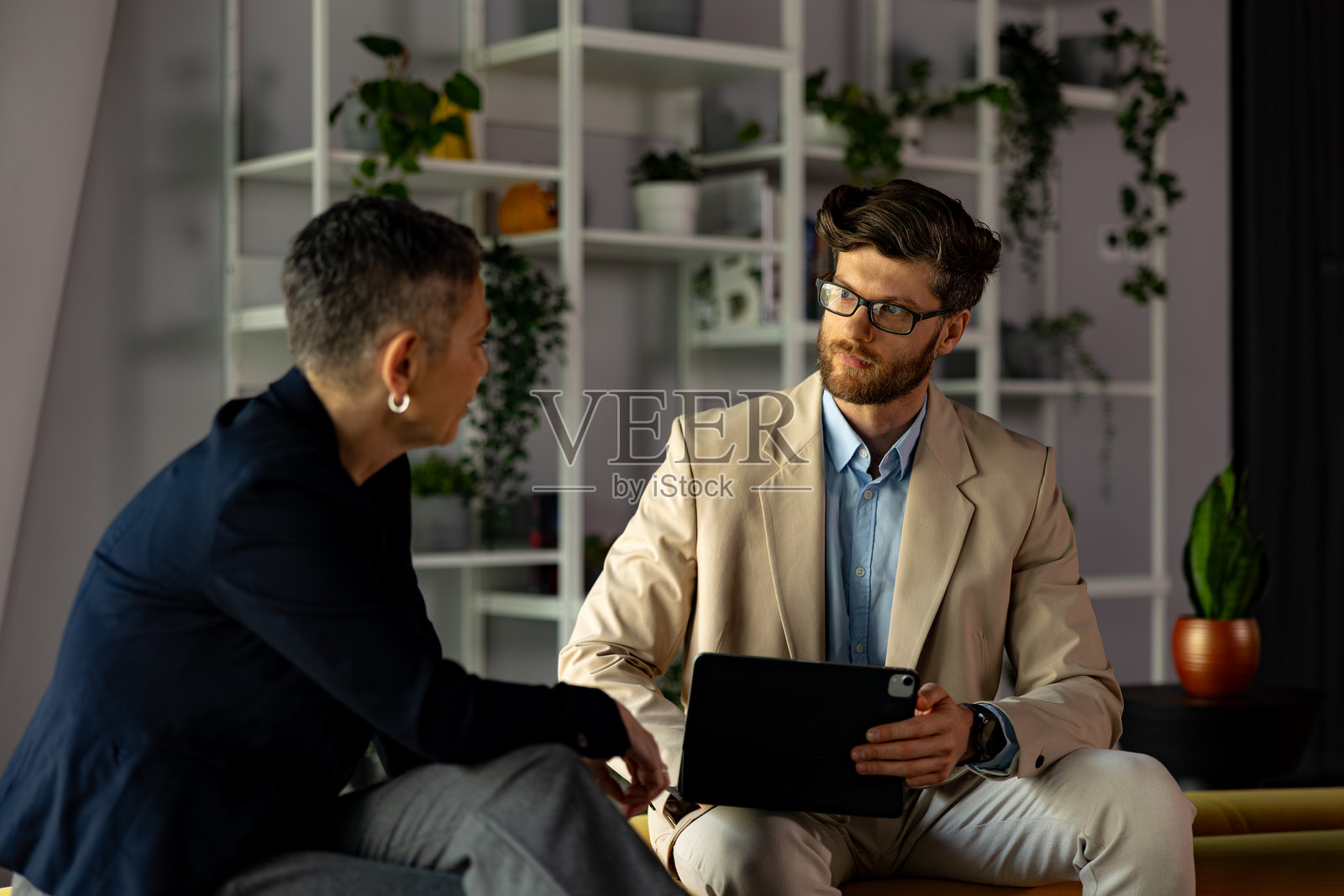 商务人士在办公室会议中使用平板电脑进行讨论照片摄影图片