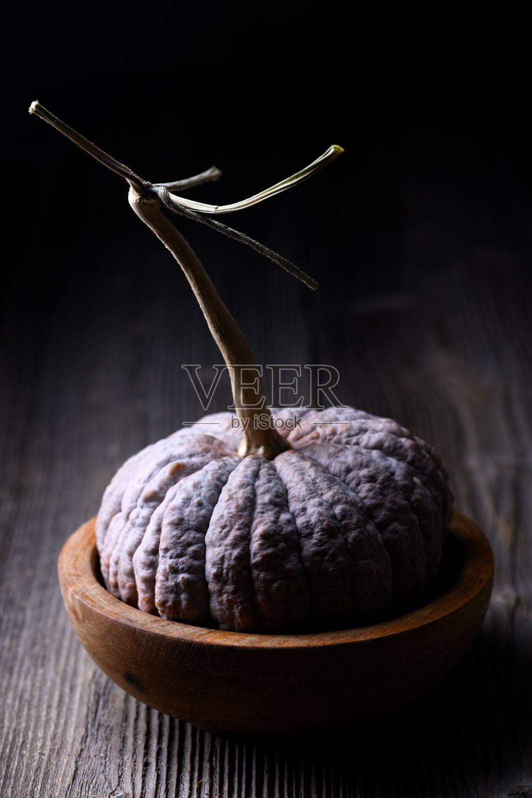 黑色福土南瓜，皱纹皮肤，静静地放在木质桌面上照片摄影图片