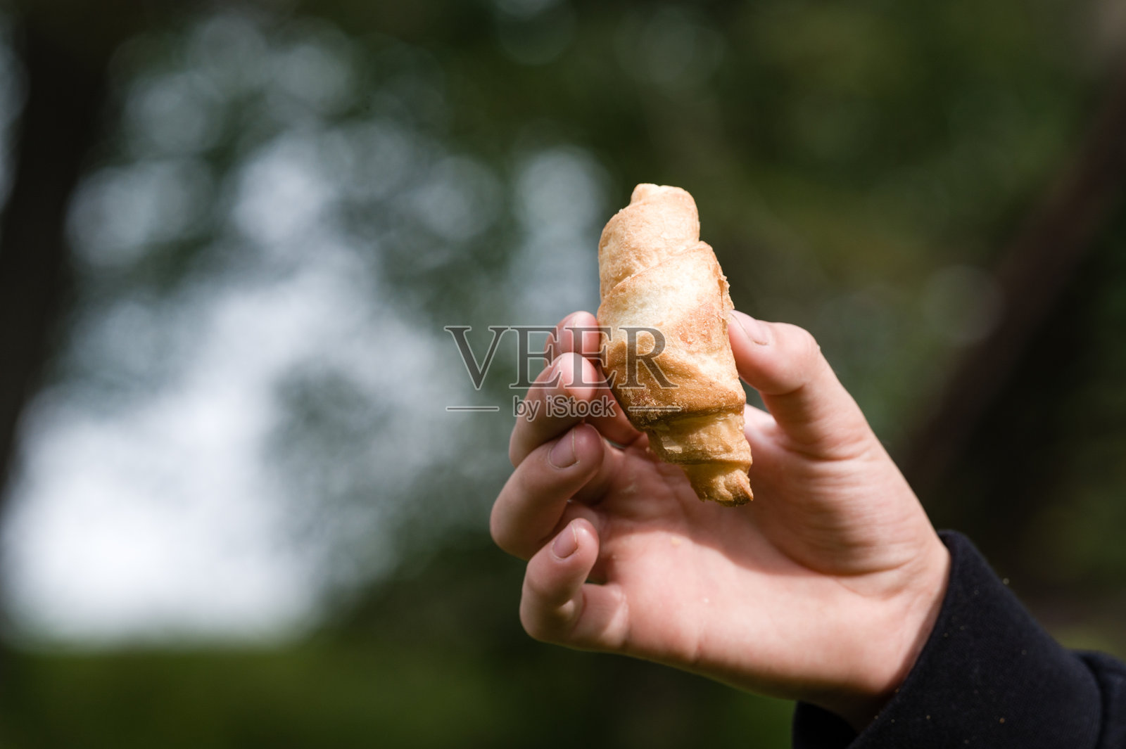 手握小糕点在户外照片摄影图片