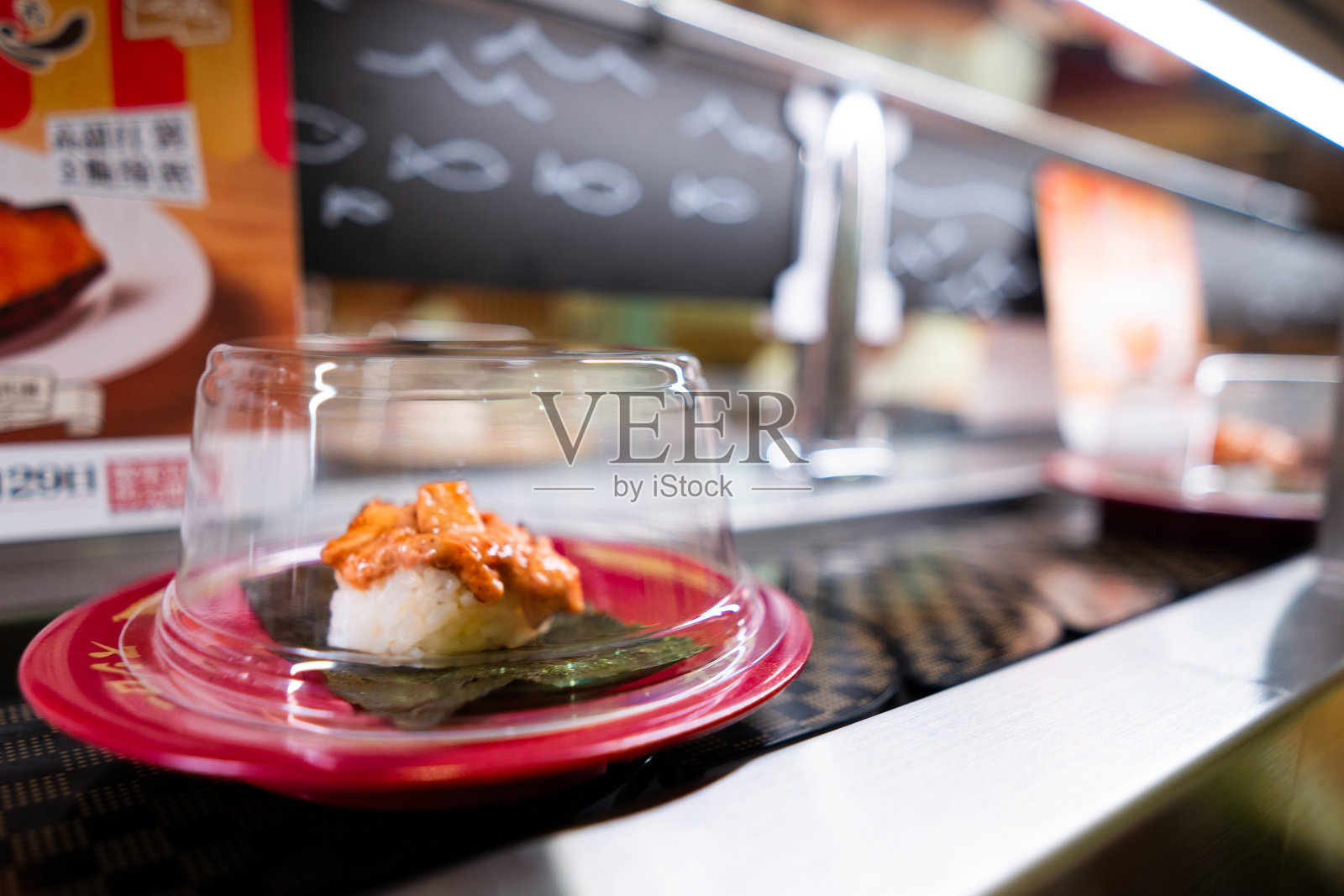 在亚洲日本餐厅，寿司食物通过传送带送达。照片摄影图片