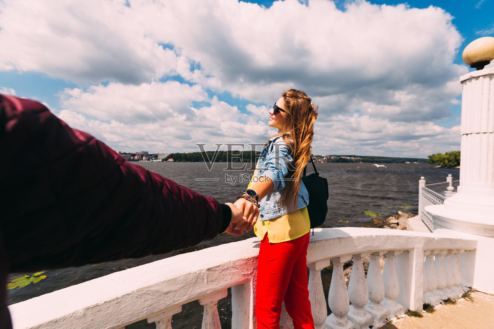 湖岸和白色栅栏。男孩牵着女孩的手。照片摄影图片